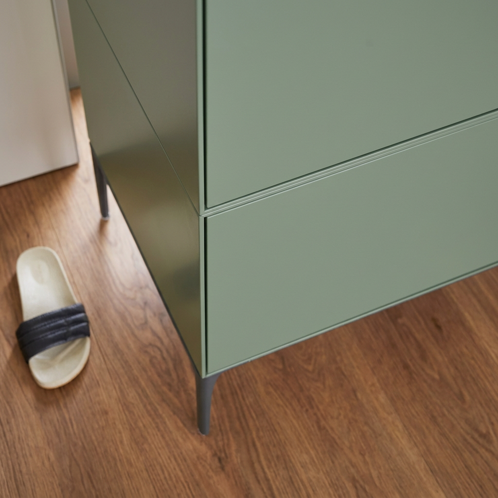A sage green Treku Lauki cabinet featuring five asymmetrical doors and black metal legs in a contemporary design.