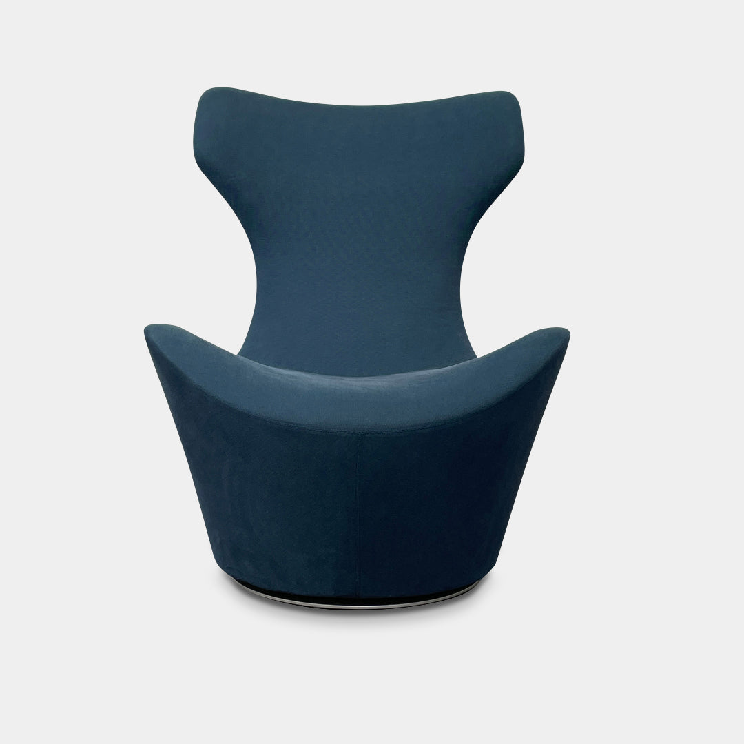 The B&B Italia Grande Papilio Swivel Chair with Ottoman features a modern design inspired by Naoto Fukasawa, with a dark blue finish, wide seat, curved armrests, and a high winged backrest—a signature piece from B&B Italia.