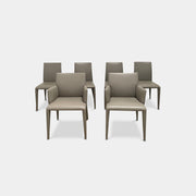 Six B&B Italia Vol au Vent Dining Chairs, embodying the elegance of Italian style, are arranged in two rows in an empty room with a concrete floor and a plain white wall.