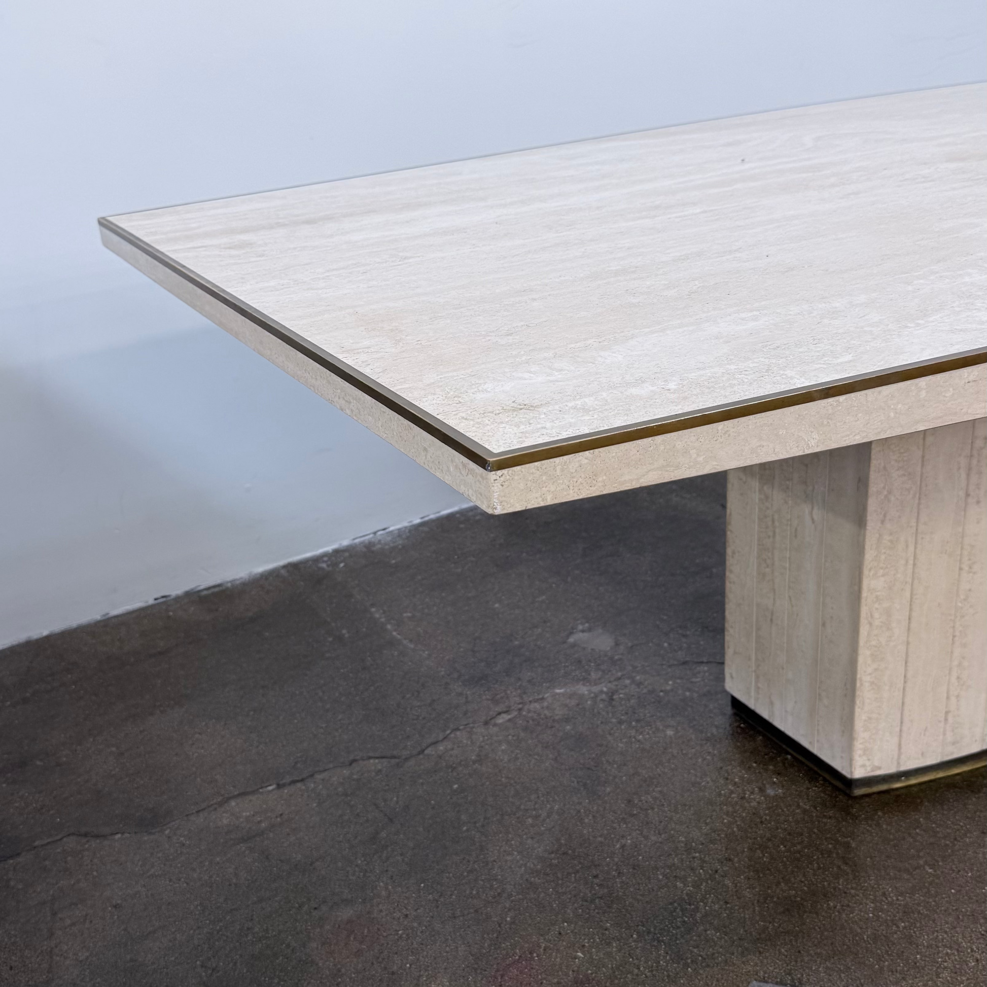 Rectangular Travertine and Brass Dining Table by Willy Rizzo with a brass edge inlay and a central column base.