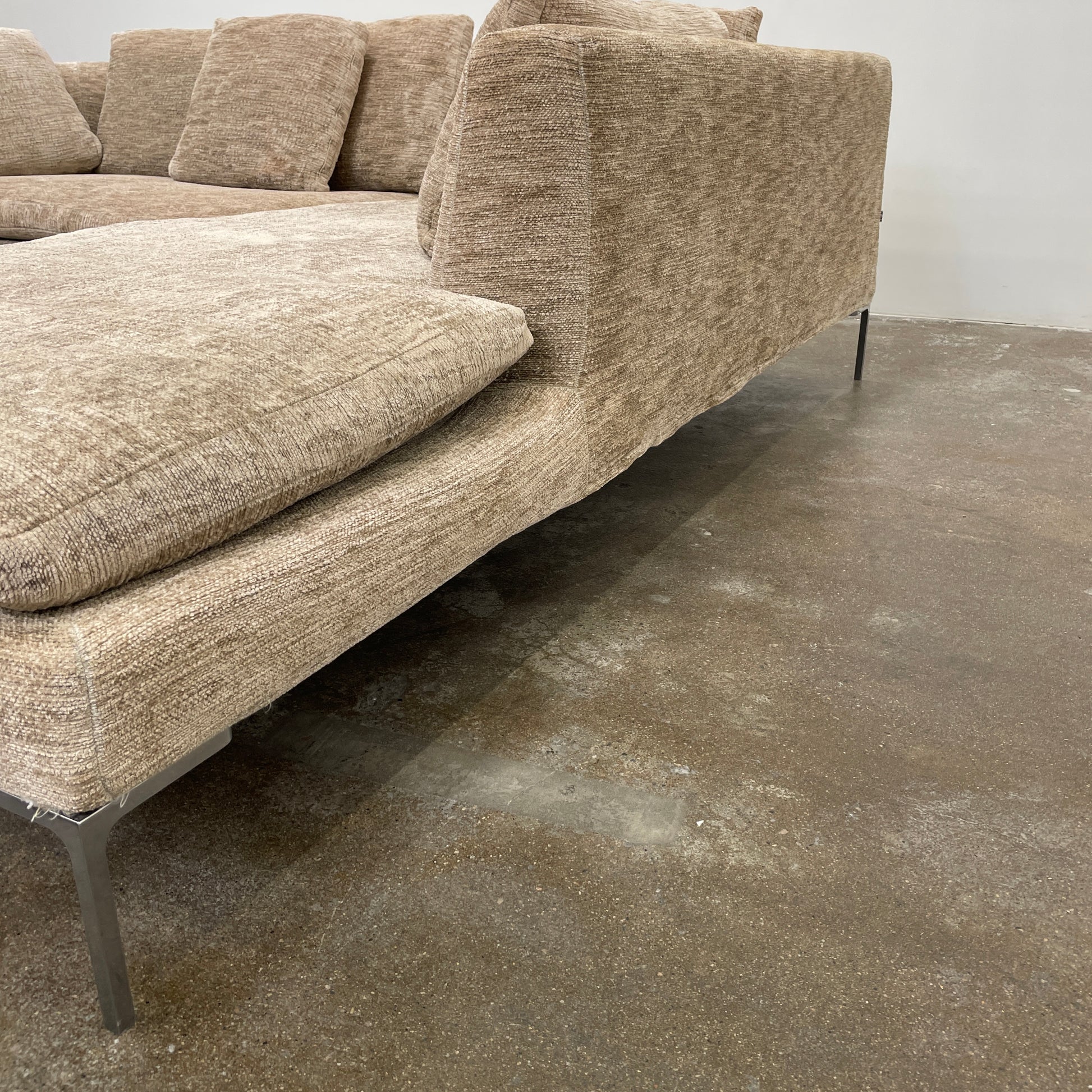 Introducing the B&B Italia Charles Sectional by Modern Resale: This beige L-shaped sectional sofa features textured fabric and stylish thin black metal legs. Set against a plain white background, it embodies modern elegance and timeless design.