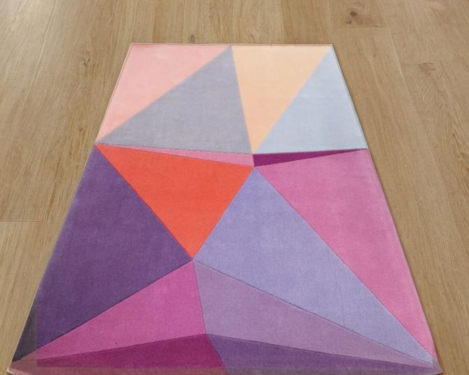 The Paul Smith Geometric Shape Split Rug Pastels features geometric designs in purple, pink, red, blue, and peach tones on a crisp white background.
