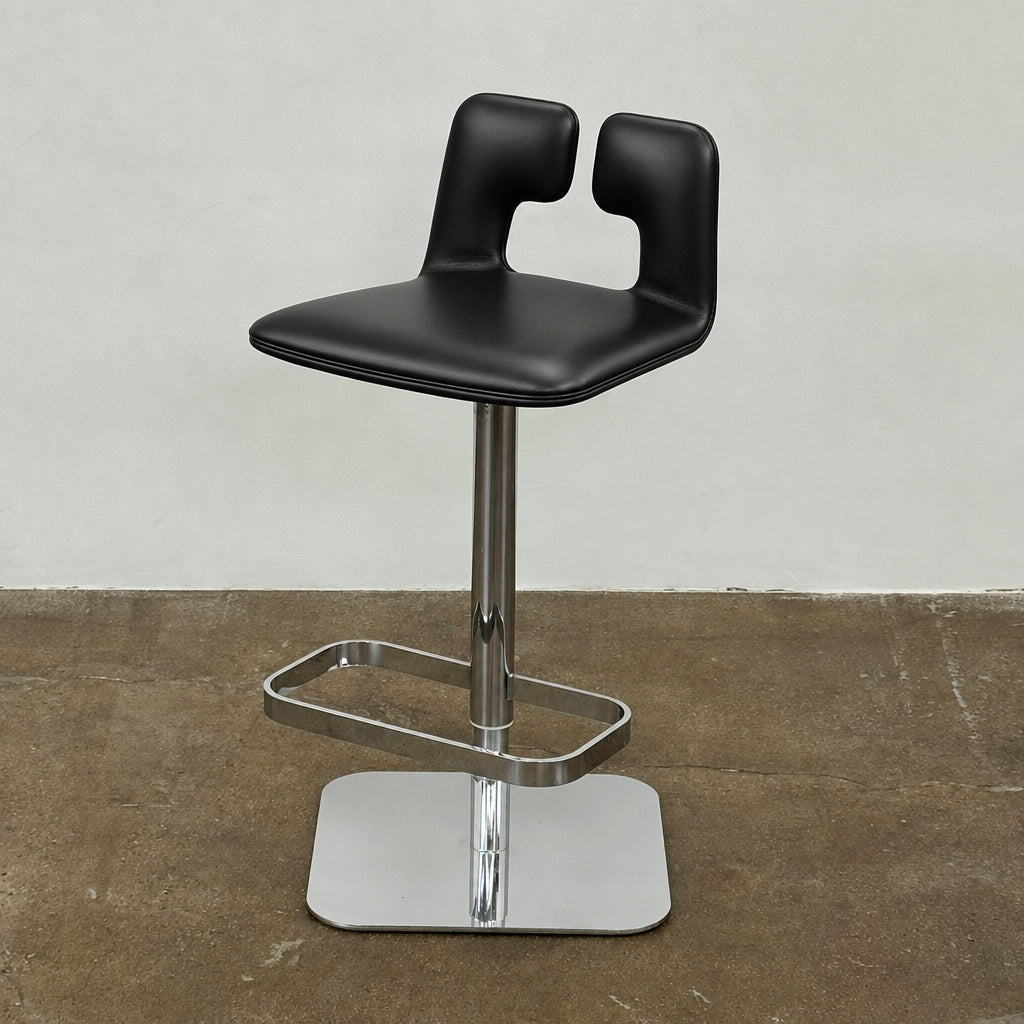 Four Poltrona Frau ALO Revolving Counter Height Adjustable Stools in black leather with chrome bases are arranged in a row, highlighting their modern design against a white background.