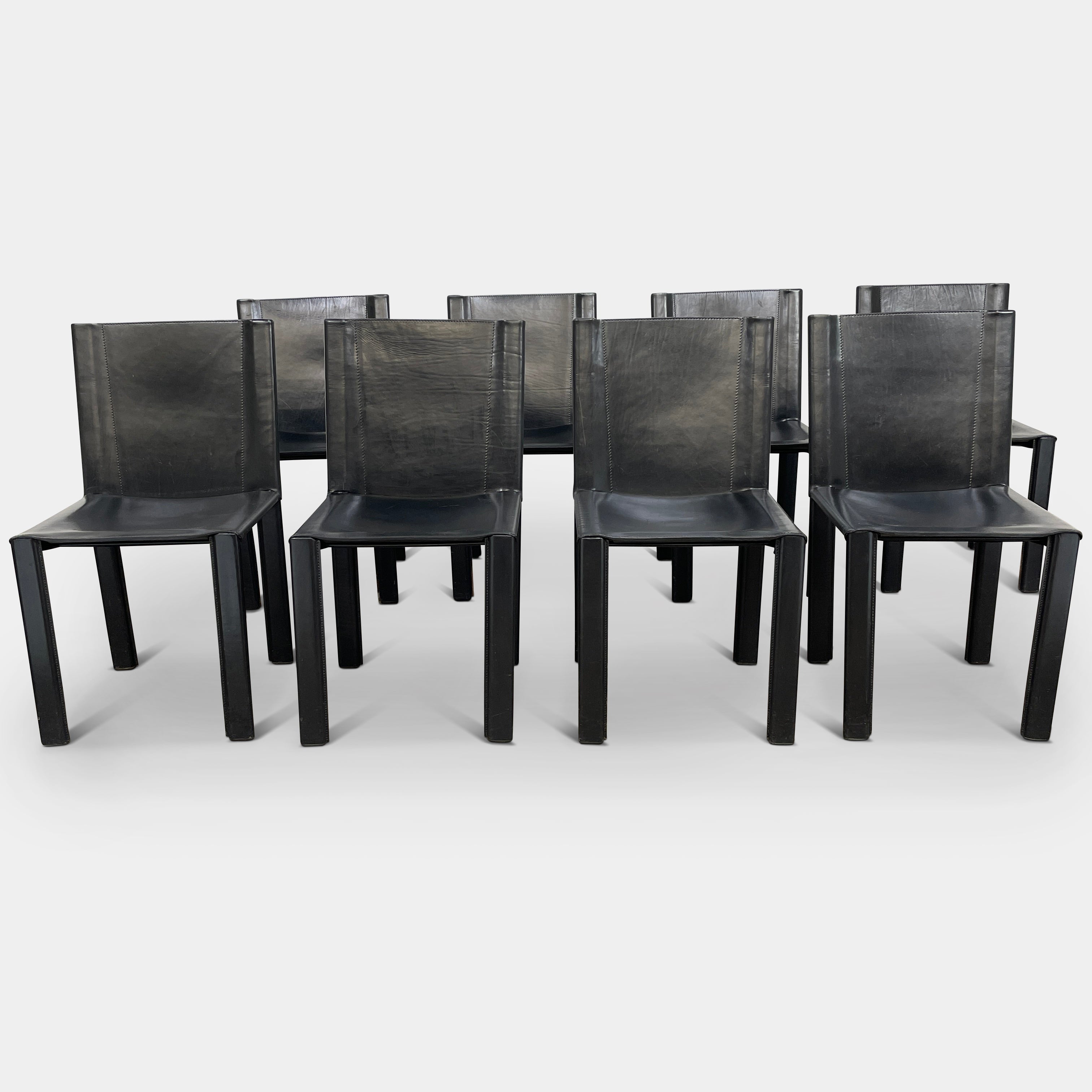 Eight Vintage Matteo Grassi 'Coral' dining chairs, showcasing a sleek black finish, are arranged in two rows on a pristine white background.