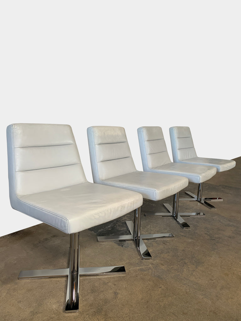 A set of four Ligne Roset Guggen Swivel Chairs on a white background.