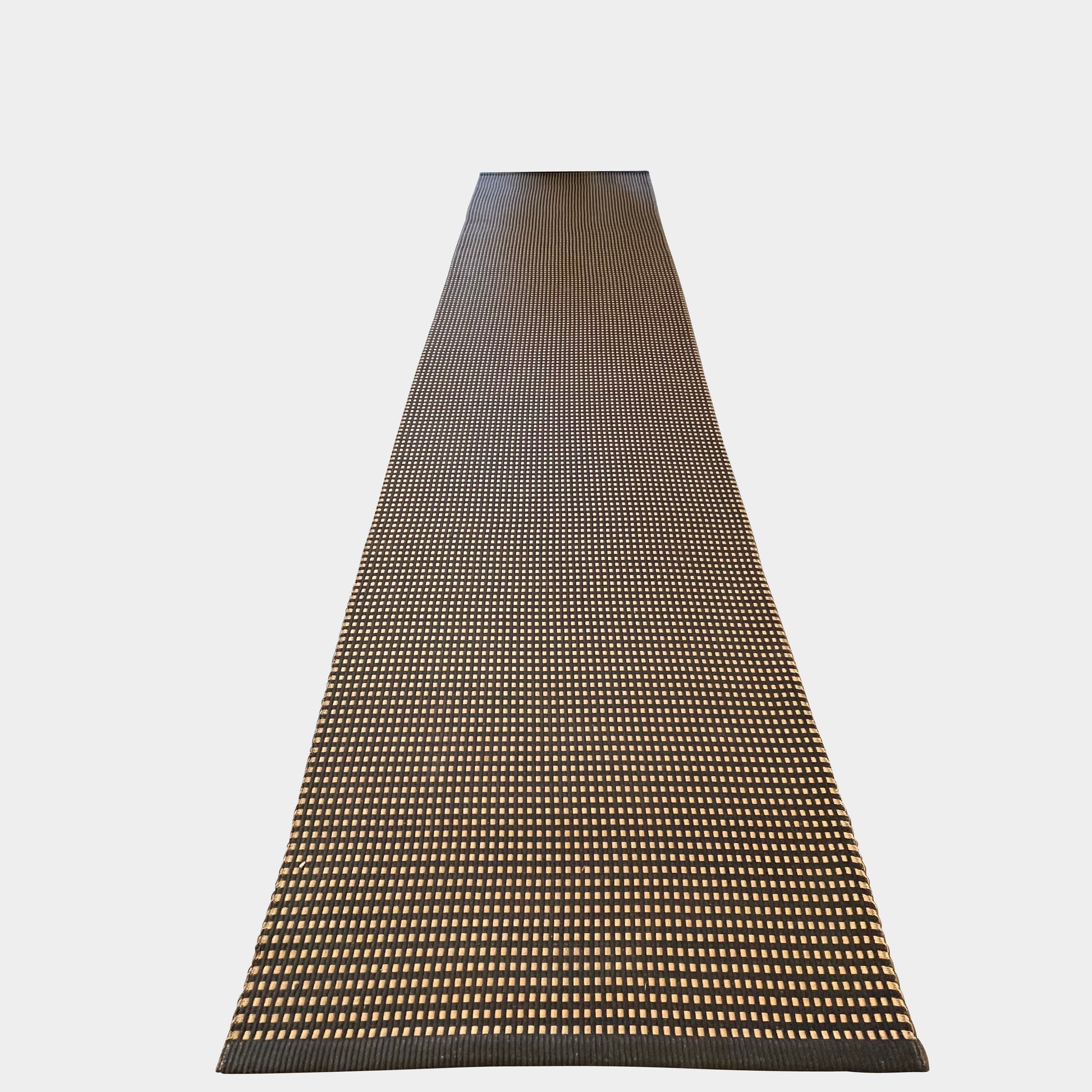 An indoor/outdoor Woodnotes City Rug with cozy detail, in black and tan, on a white surface.