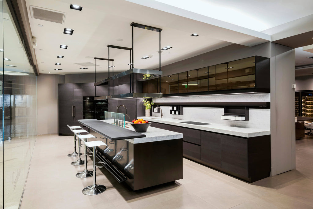 Modern kitchen interior with a sleek design featuring a central island, bar stools, and pendant lighting, embodying the luxury of Arclinea.
