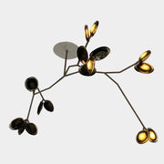 The Bocci Armature Chandelier T16.17aA1 by Bocci features multiple black branches with round, illuminated bulbs extending from a central base, offering a modern ceiling light fixture design inspired by contemporary aesthetics.