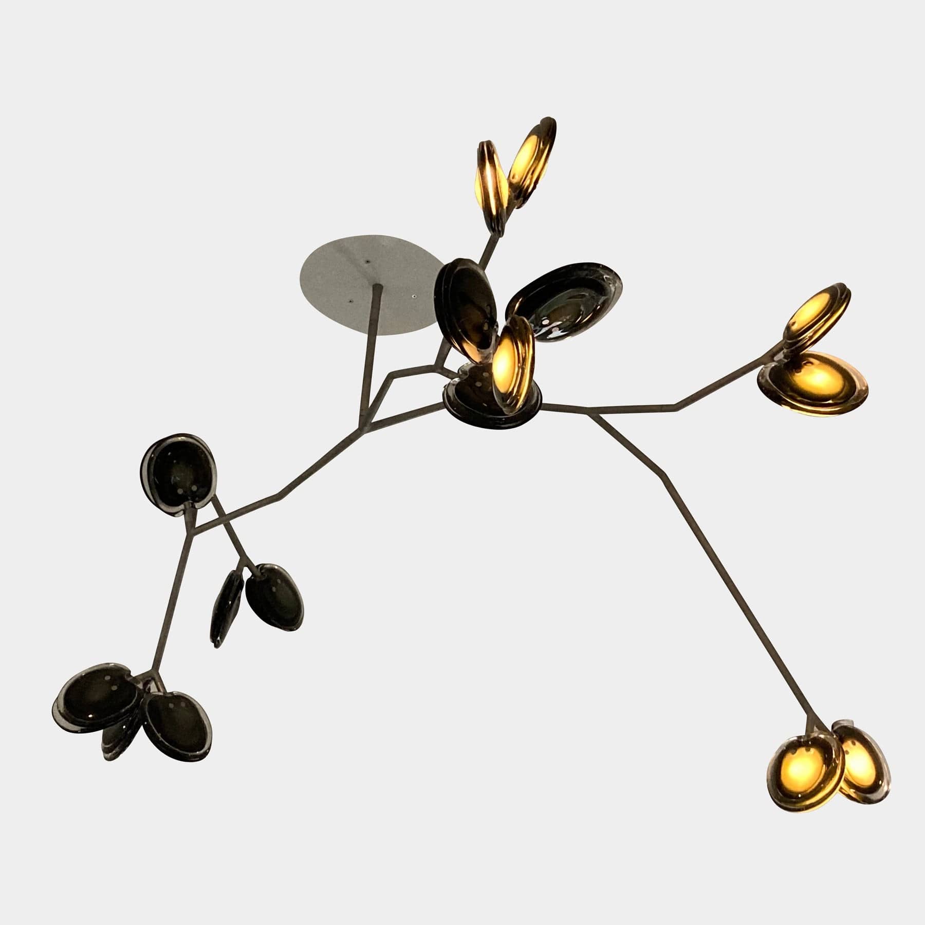 The Bocci Armature Chandelier T16.17aA1 by Bocci features multiple black branches with round, illuminated bulbs extending from a central base, offering a modern ceiling light fixture design inspired by contemporary aesthetics.