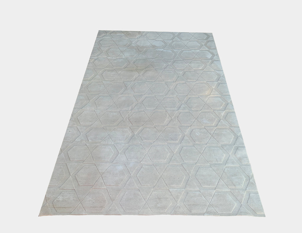 A Hi-Low Geometric Rug by Raja with geometric designs on a greige color wool.