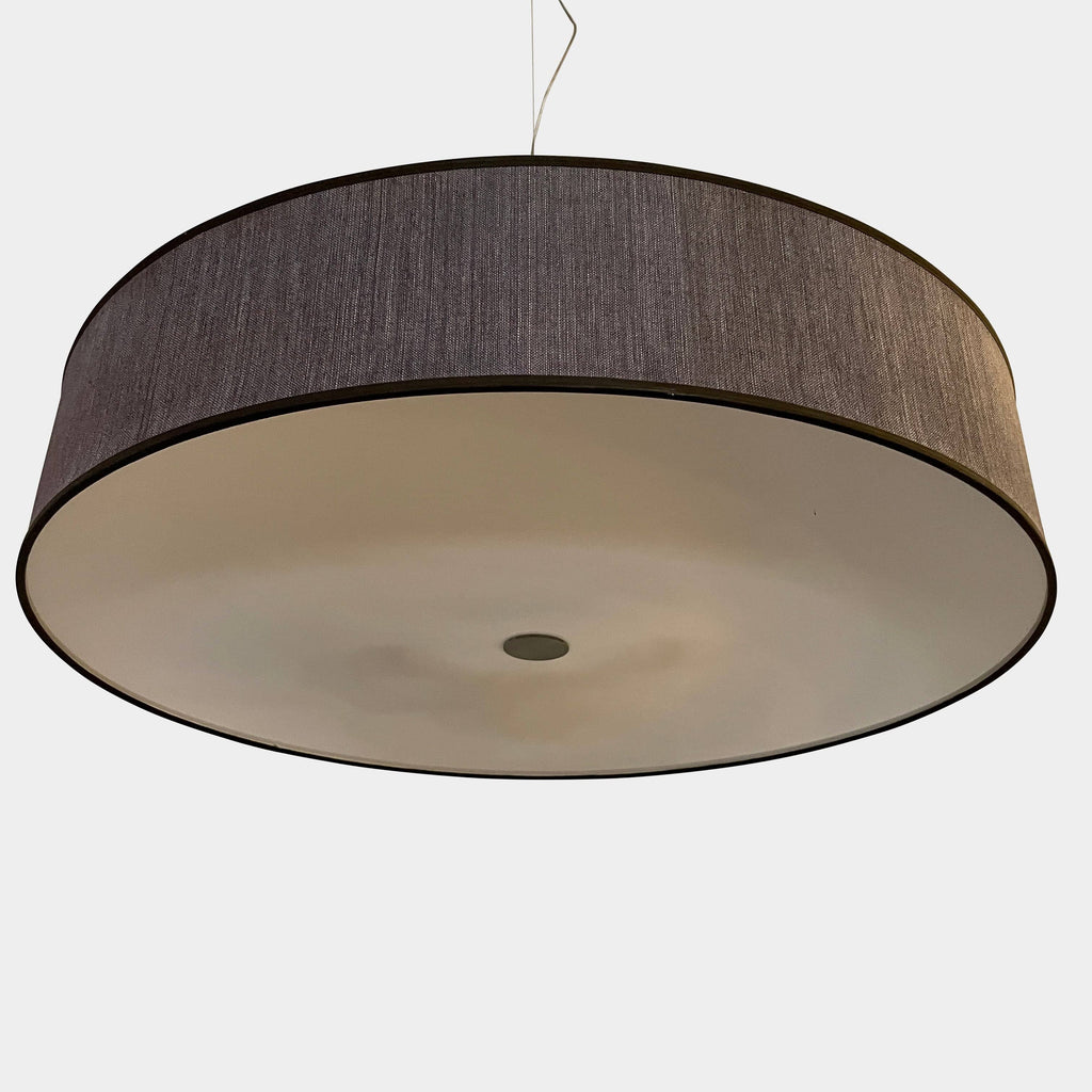 A large black Penta Low Cylinder pendant light hanging from a low ceiling.