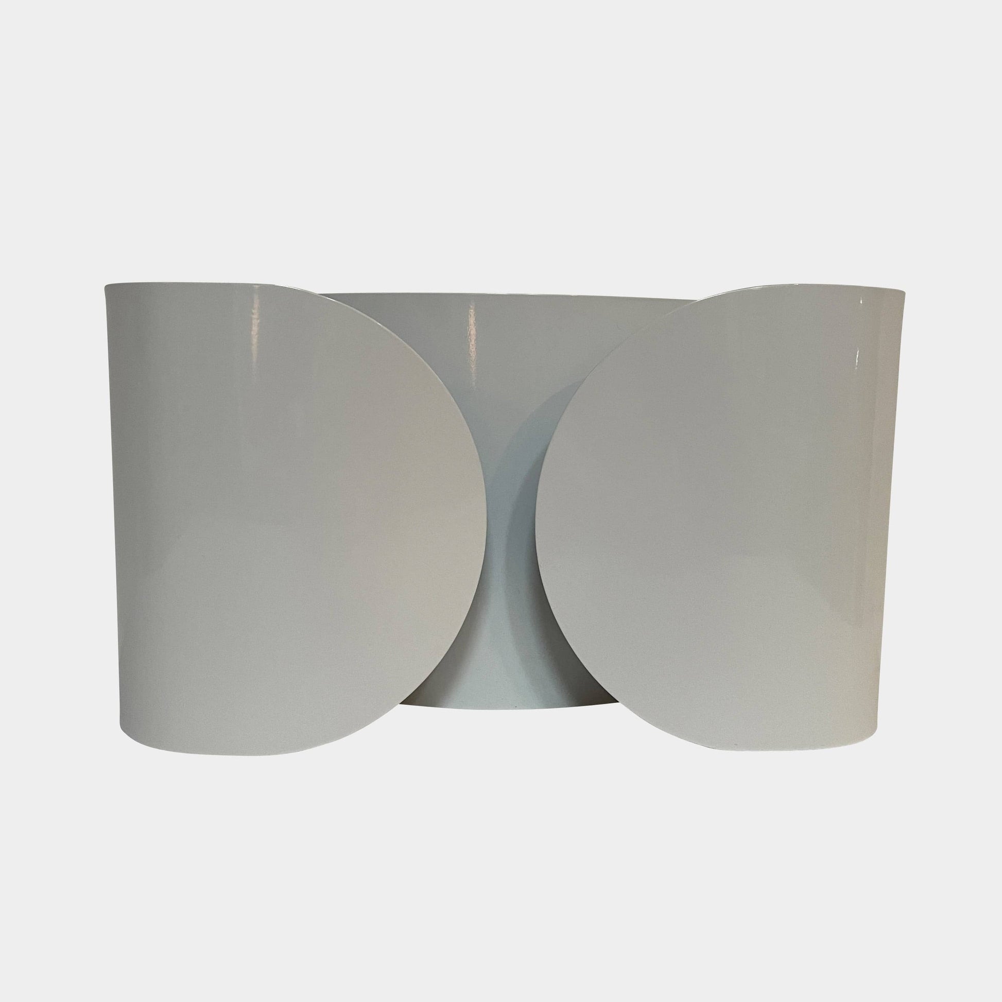 A set of Flos Foglio Wall Sconces emitting indirect light on a steel surface.