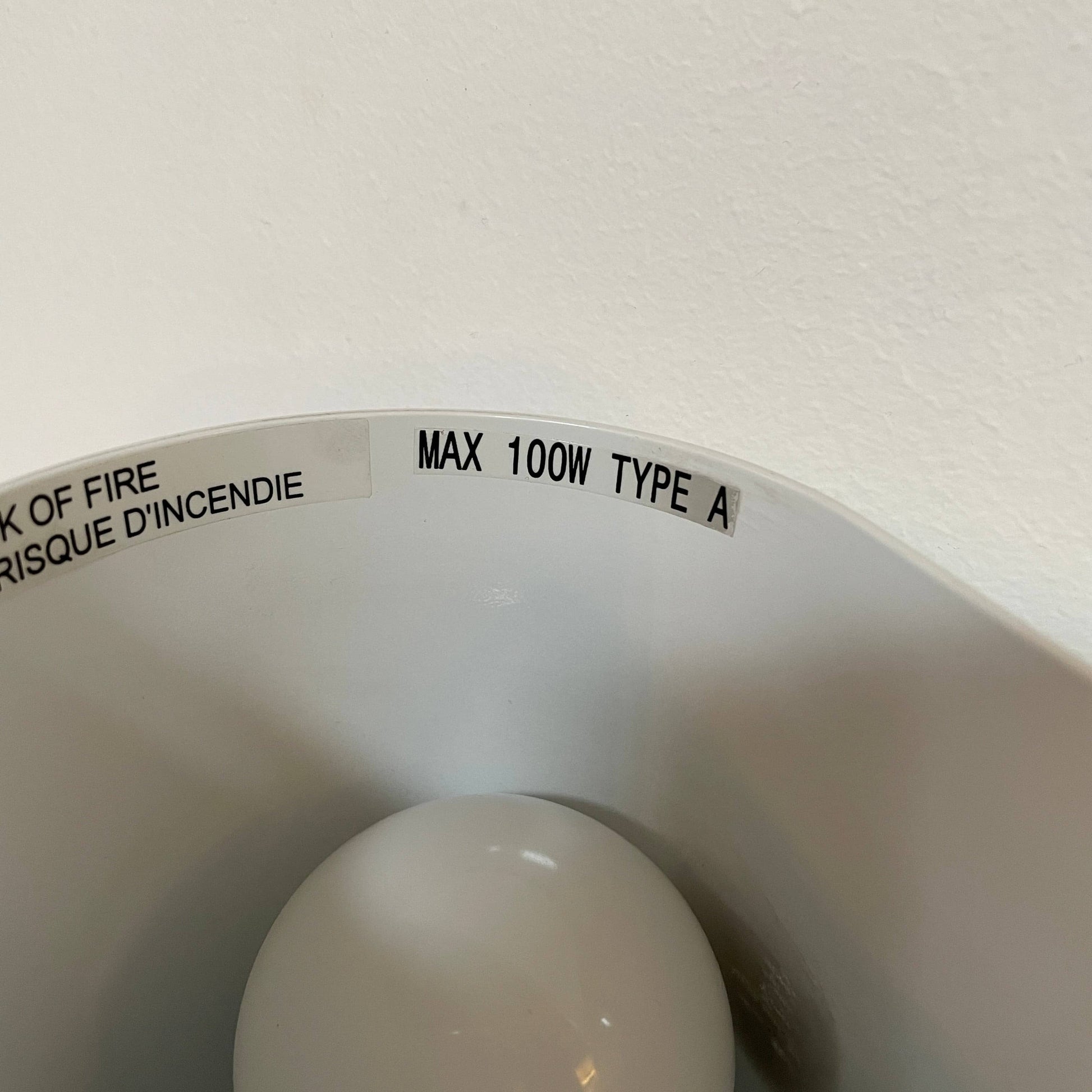 A set of Flos Foglio Wall Sconces emitting indirect light on a steel surface.