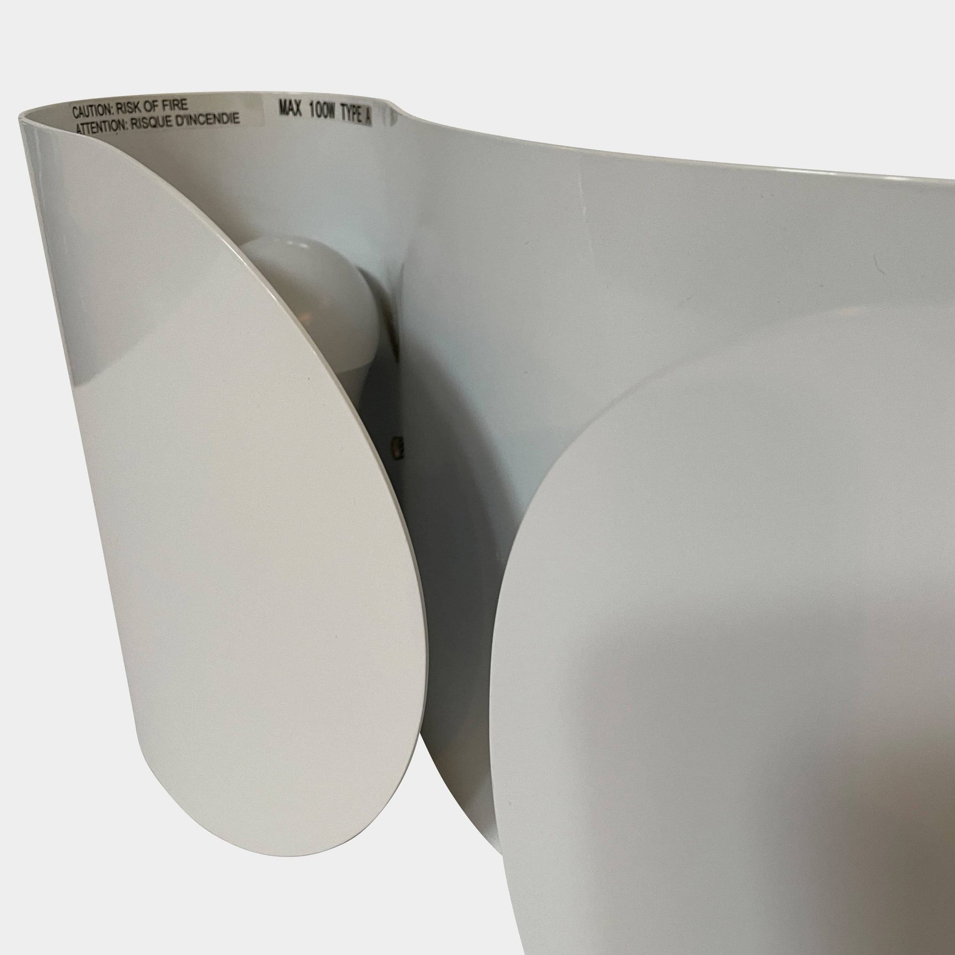 A set of Flos Foglio Wall Sconces emitting indirect light on a steel surface.