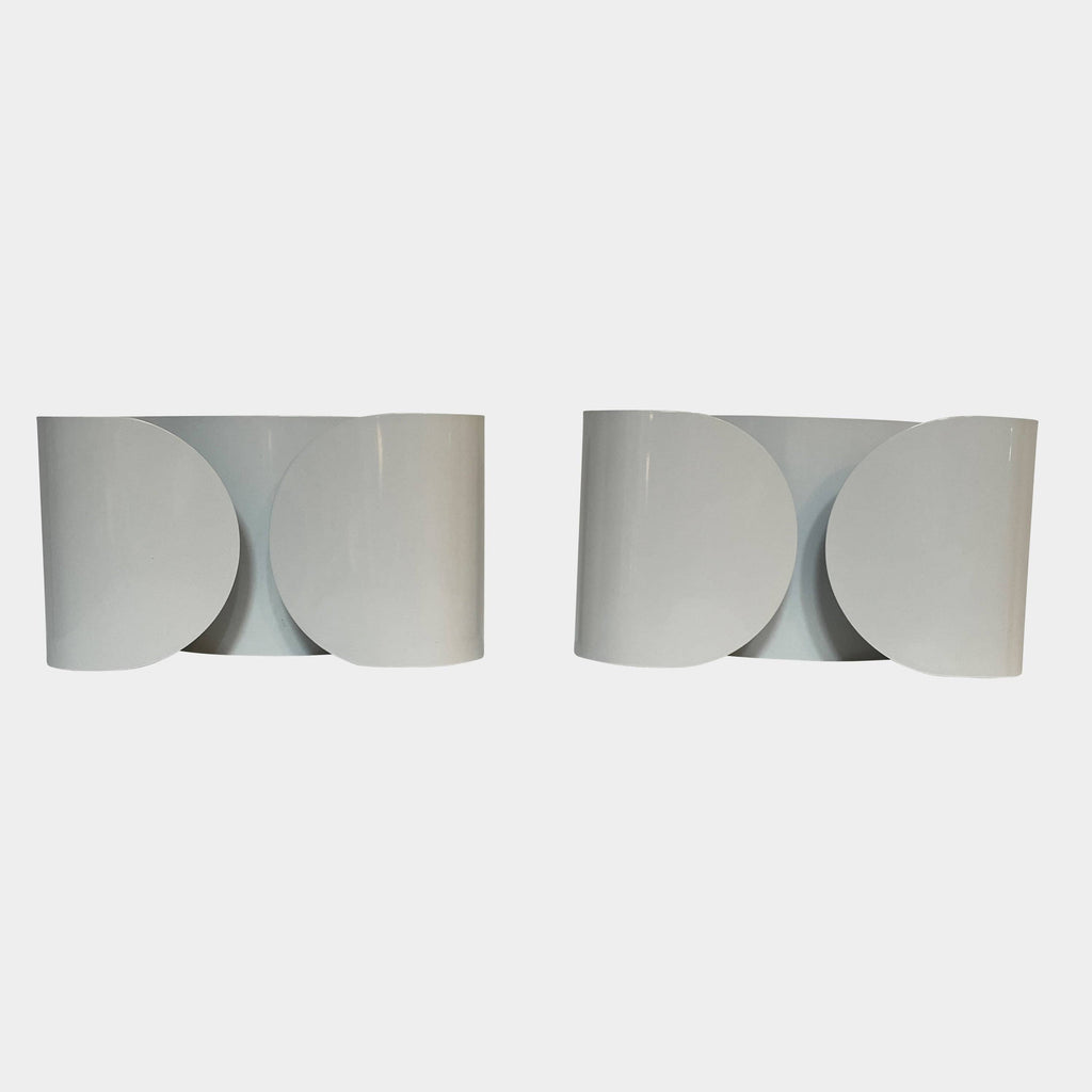 A set of Flos Foglio Wall Sconces emitting indirect light on a steel surface.