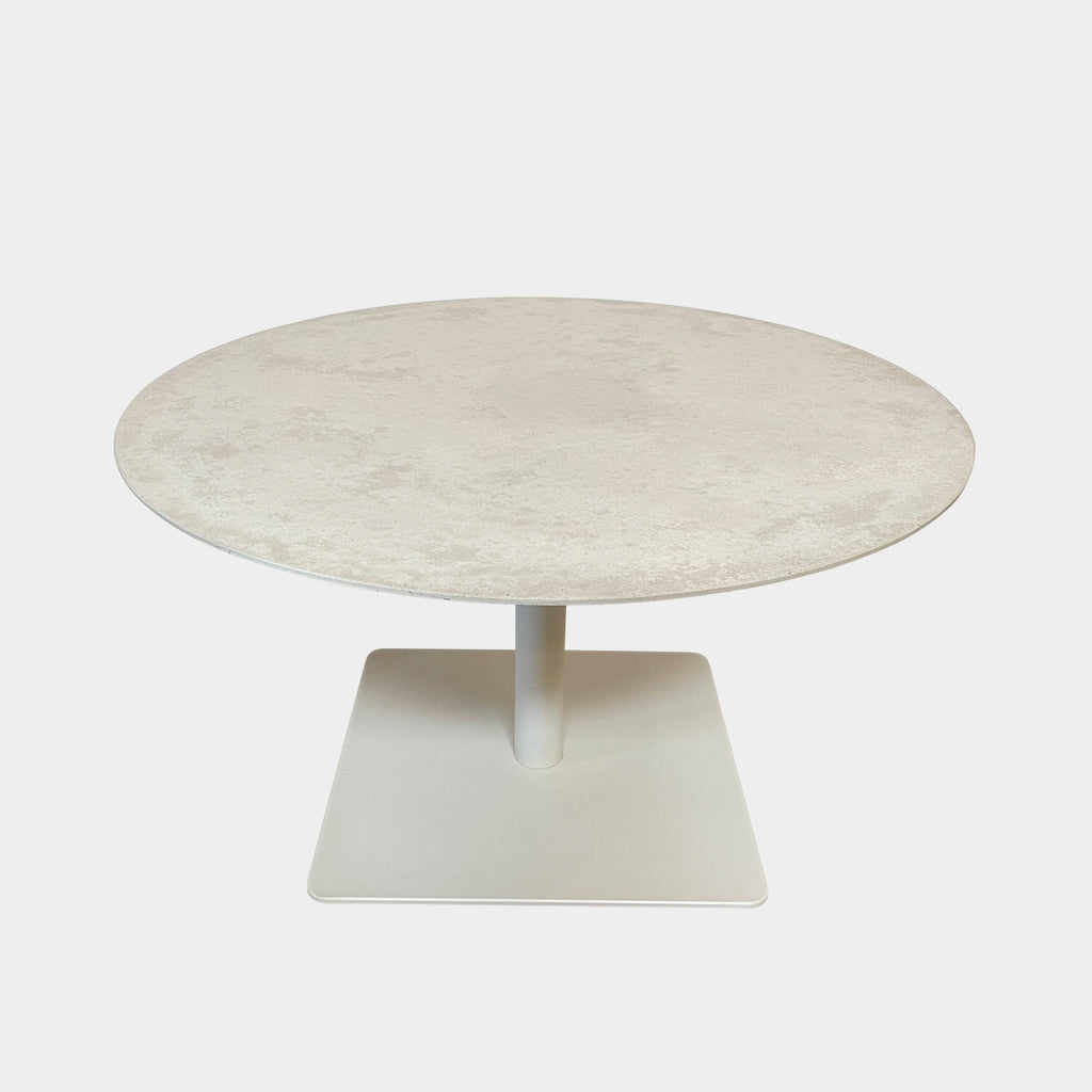 An adjustable height Giro Outdoor Table with a white base on a white background, made by Paola Lenti.