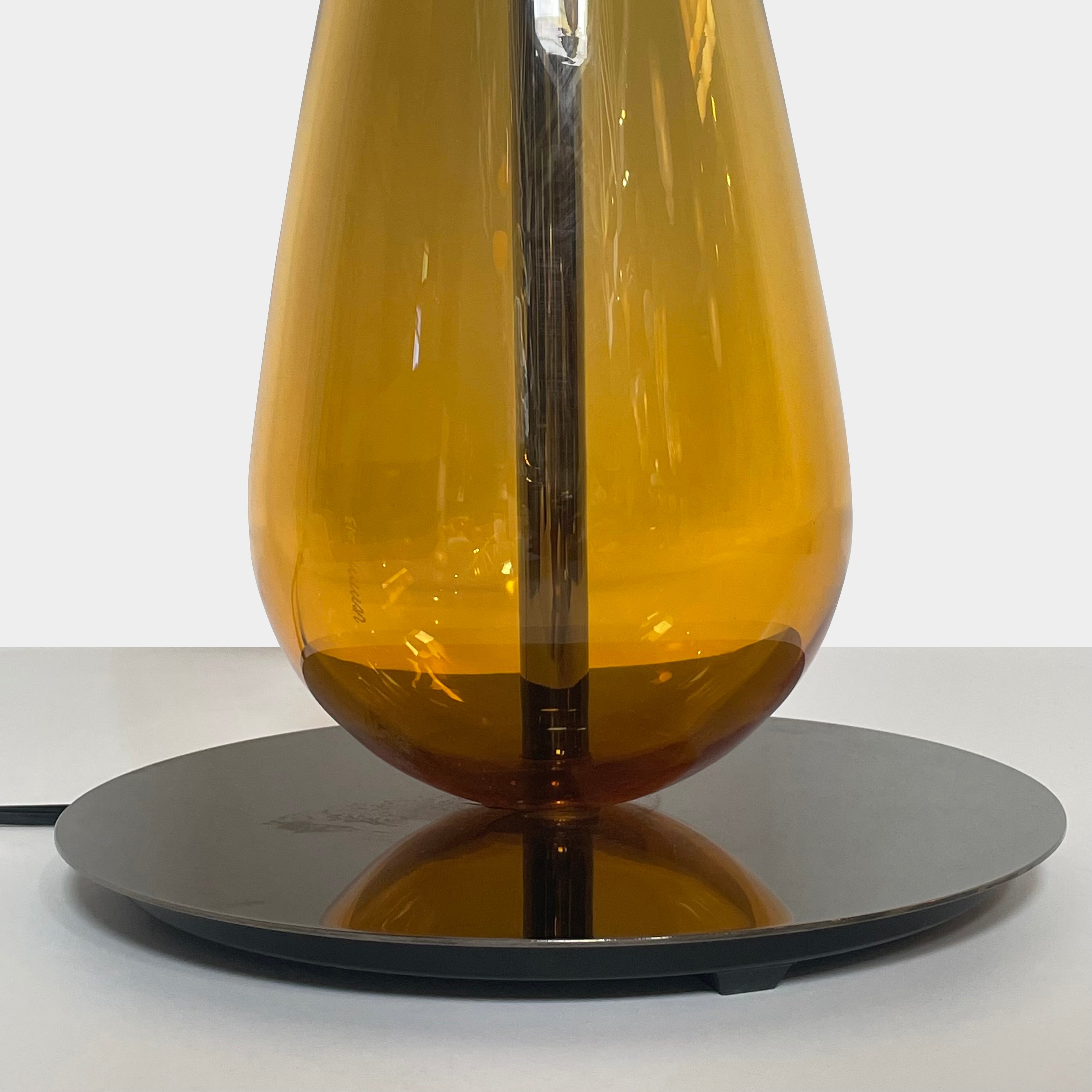 A Venini table lamp with a yellow shade and a black base.