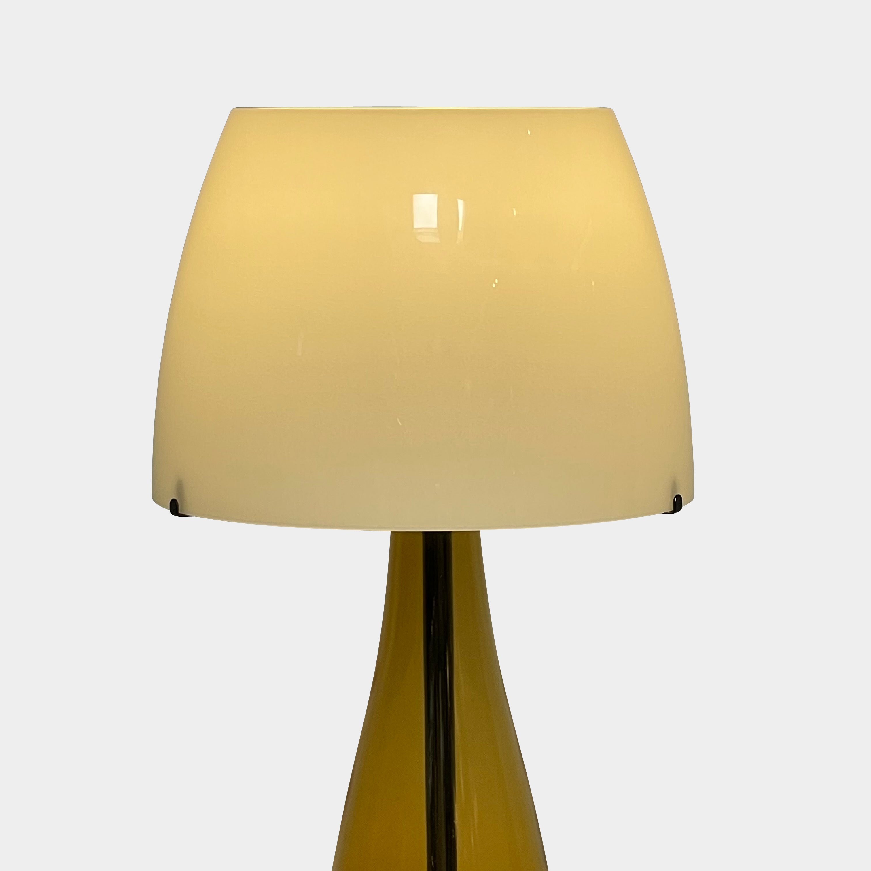 A Venini table lamp with a yellow shade and a black base.