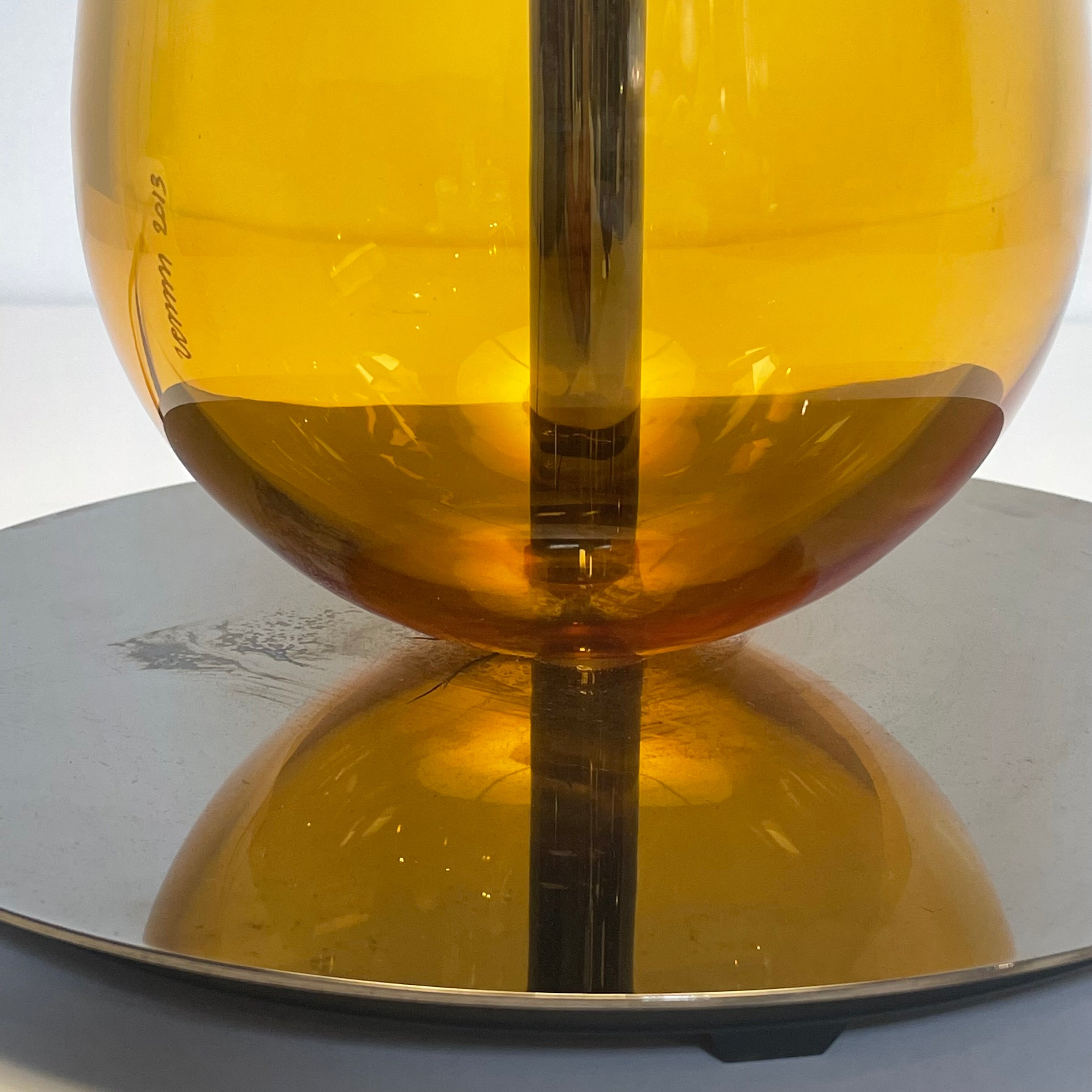 A Venini table lamp with a yellow shade and a black base.