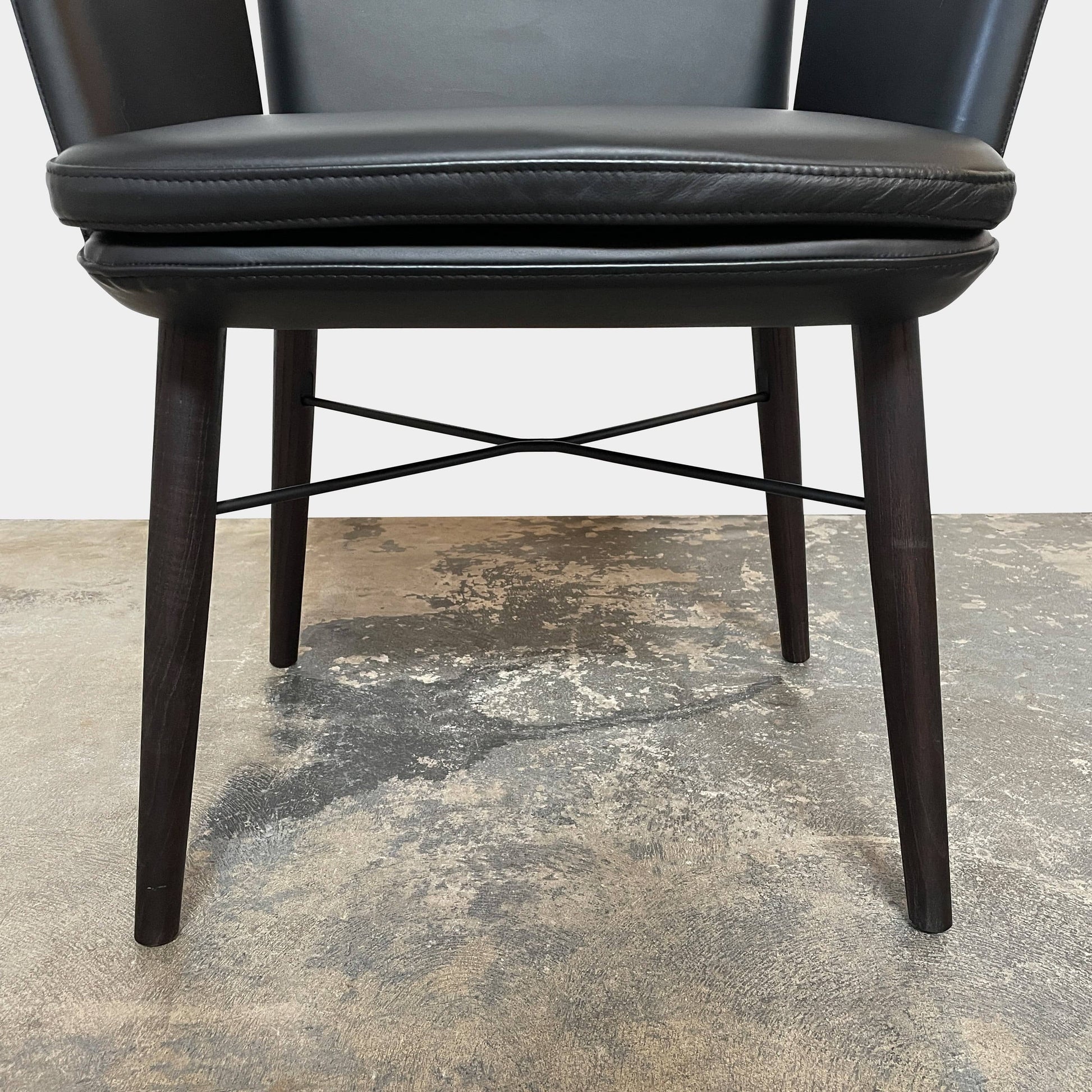 The Lema Tabby Leather Armchair by Lema features a black leather shell, accentuated by dark brown wood legs.