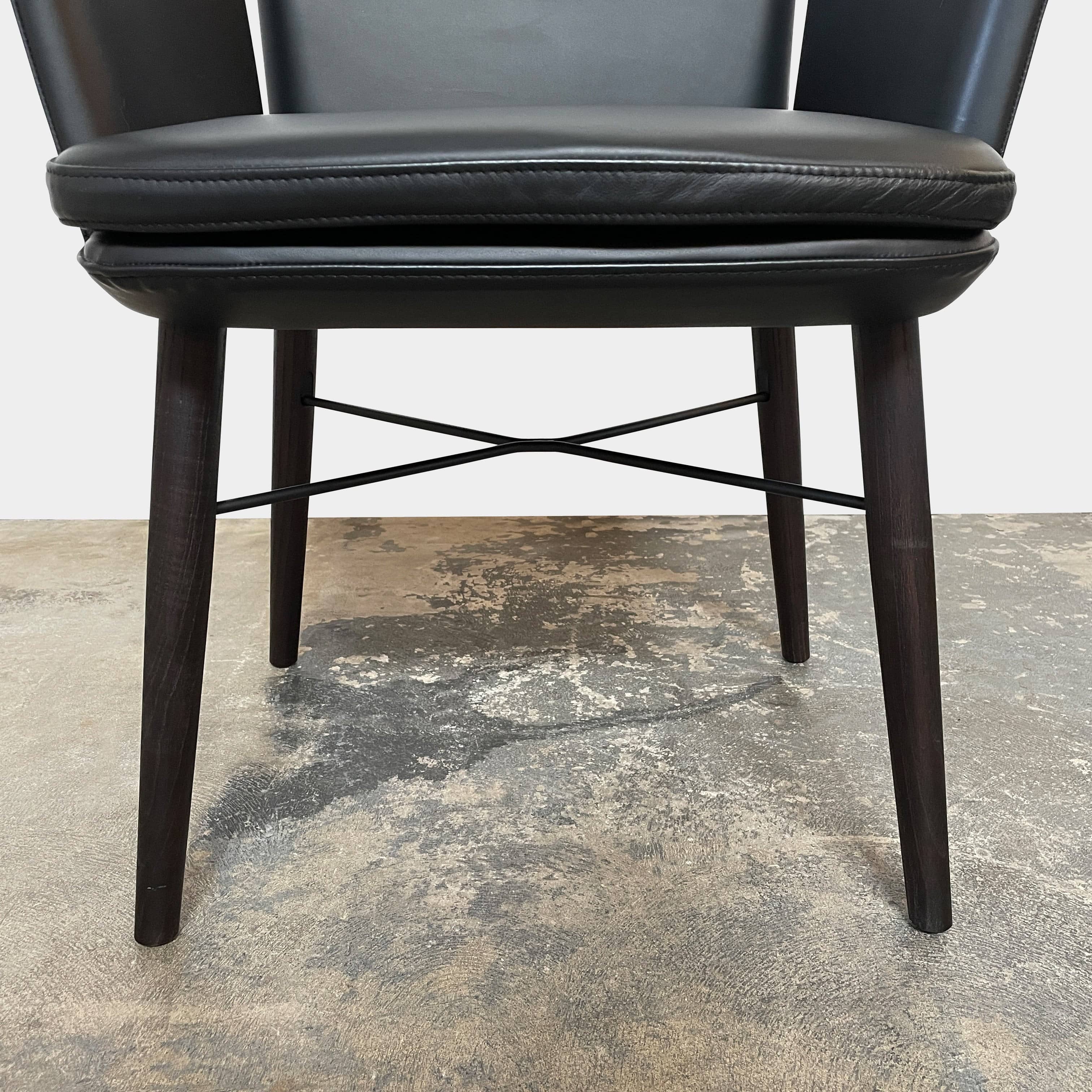 The Lema Tabby Leather Armchair by Lema features a black leather shell, accentuated by dark brown wood legs.