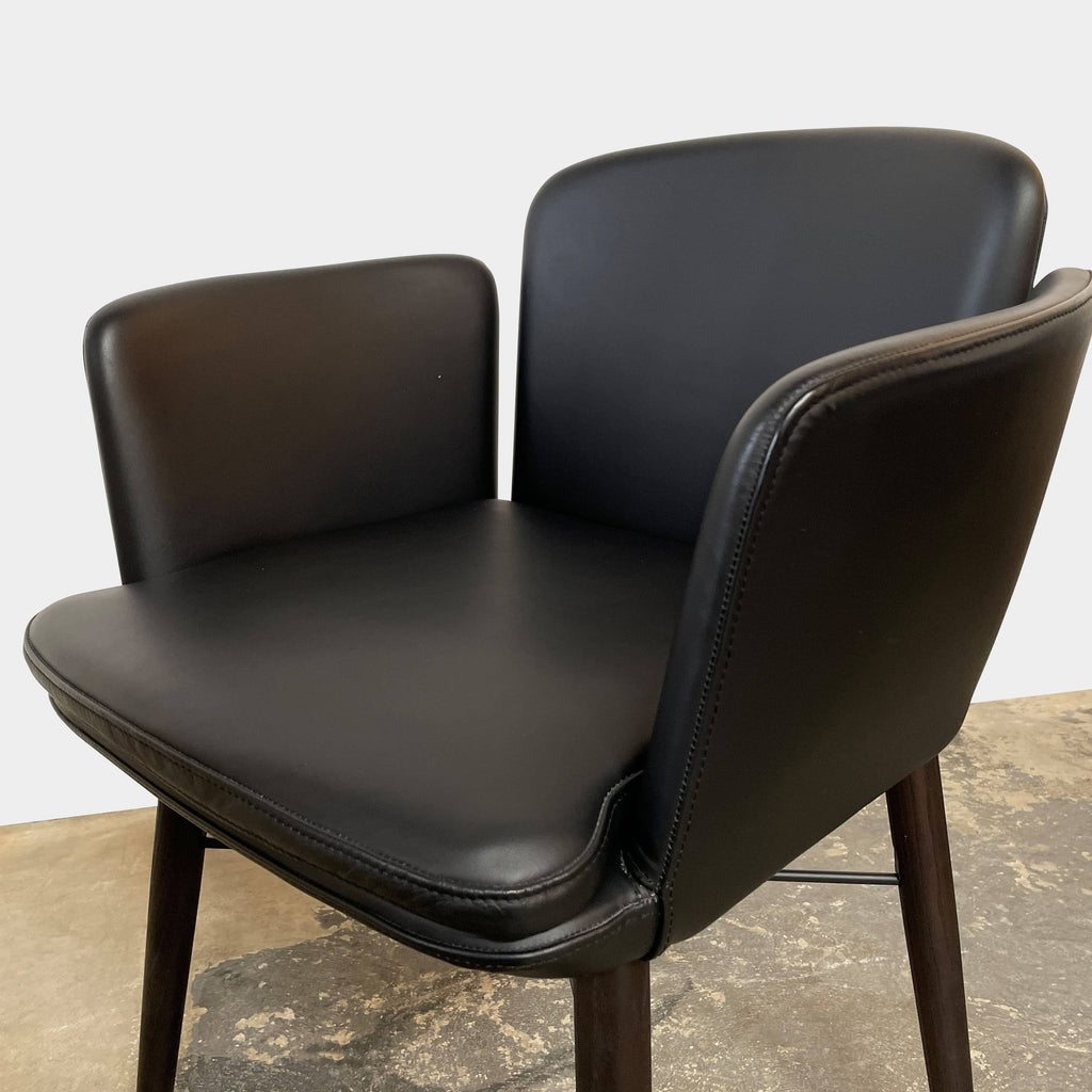 The Lema Tabby Leather Armchair by Lema features a black leather shell, accentuated by dark brown wood legs.