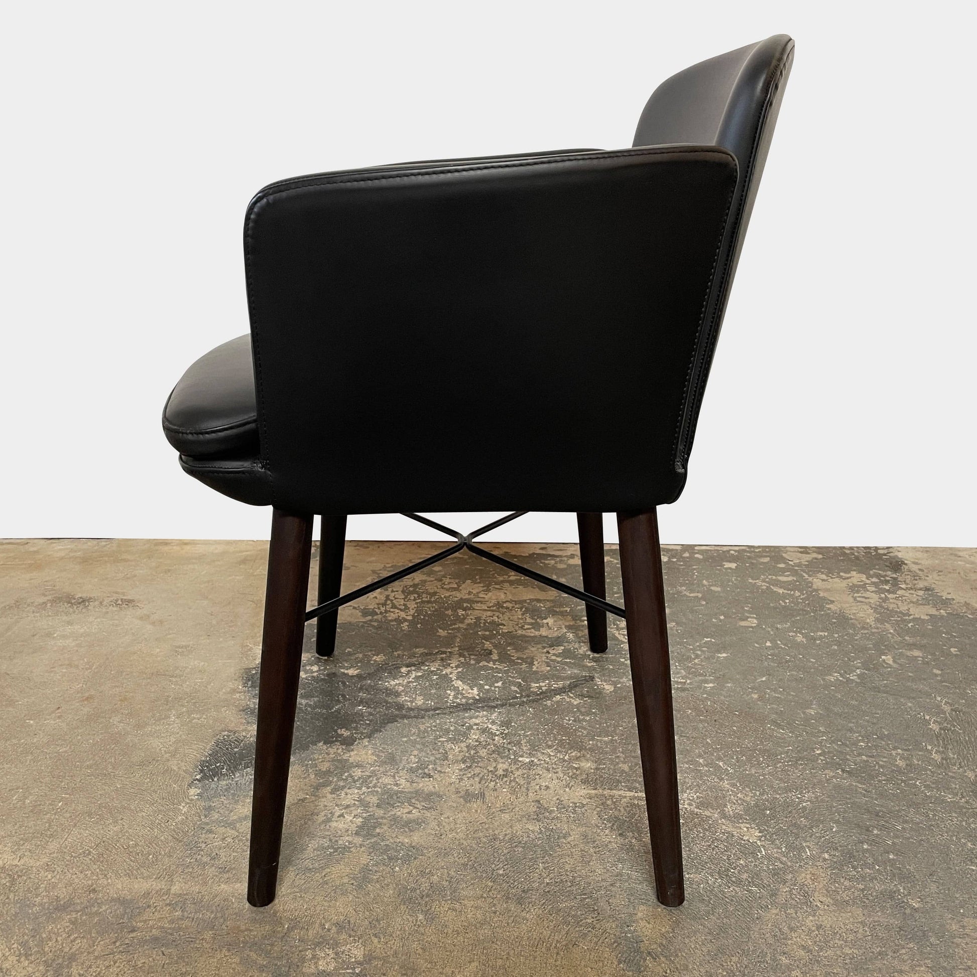 The Lema Tabby Leather Armchair by Lema features a black leather shell, accentuated by dark brown wood legs.