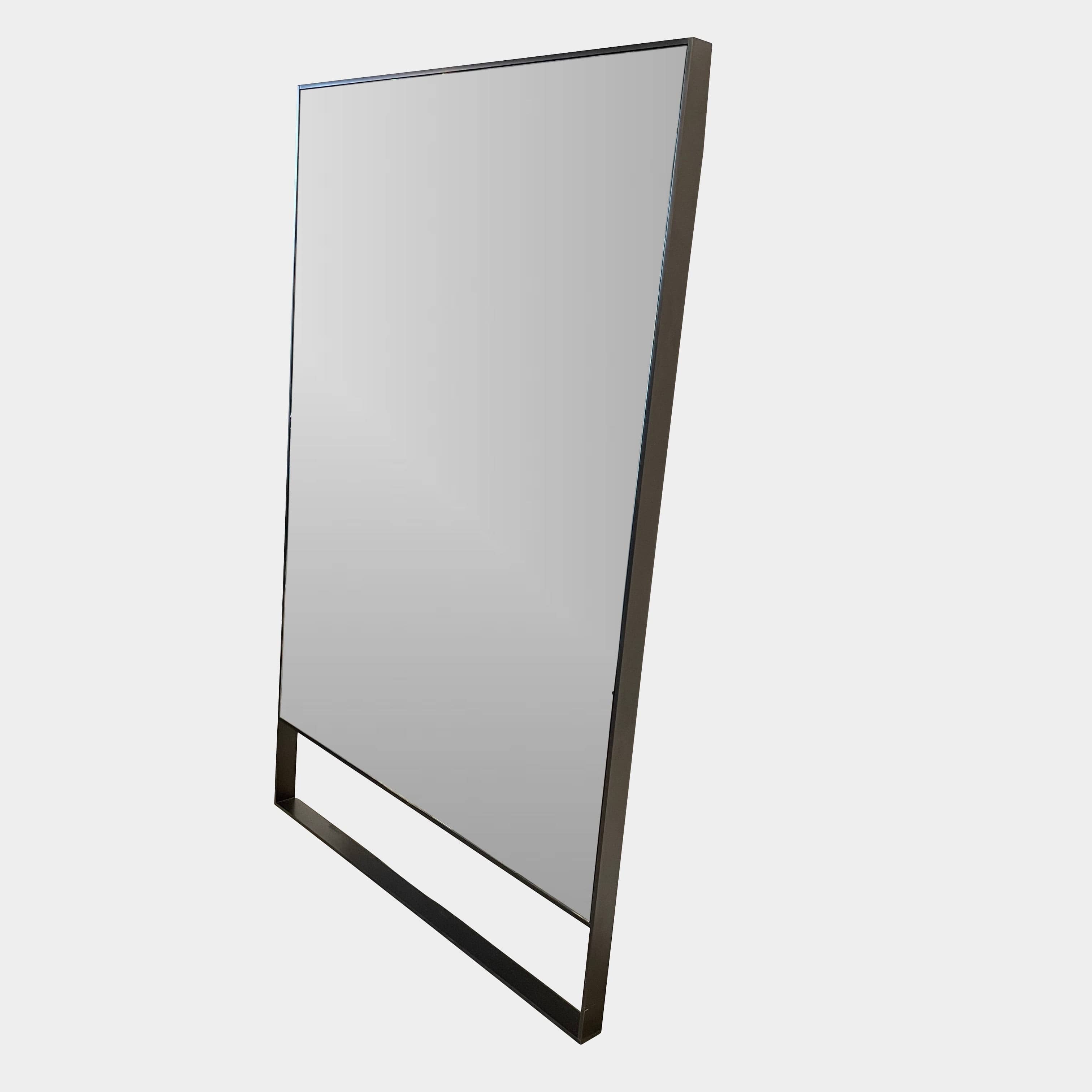 The Maxalto Psiche Leaning Mirror by Maxalto features a large rectangular shape, a slim dark frame, and a minimalist base, shown against a plain white background.