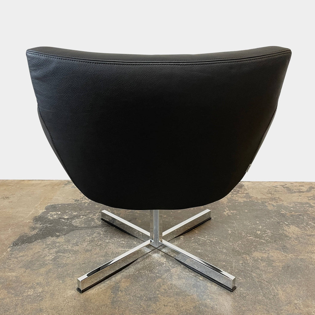 A compact black leather Team by Wellis Bocu Swivel Chair with a chrome base.