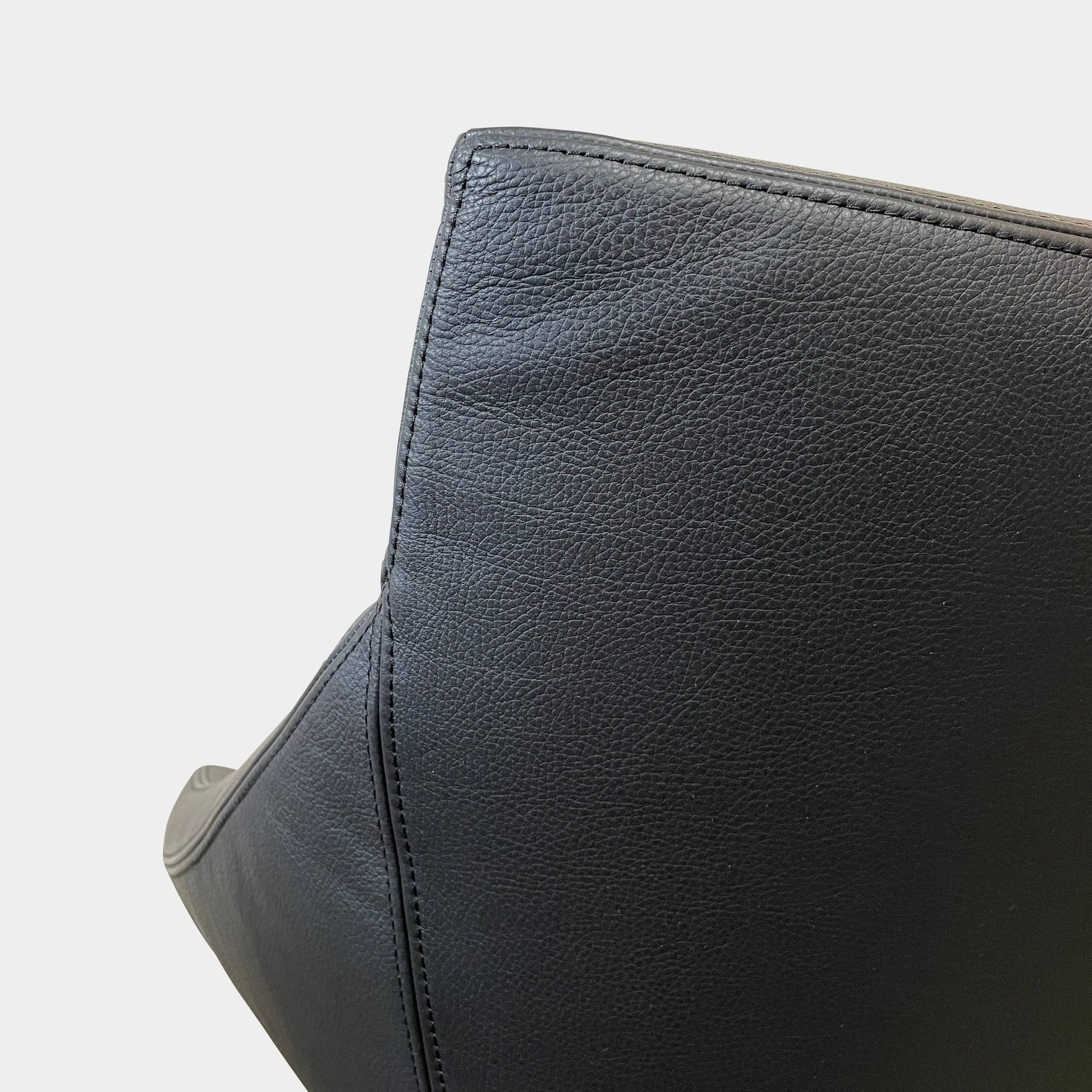 A compact black leather Team by Wellis Bocu Swivel Chair with a chrome base.