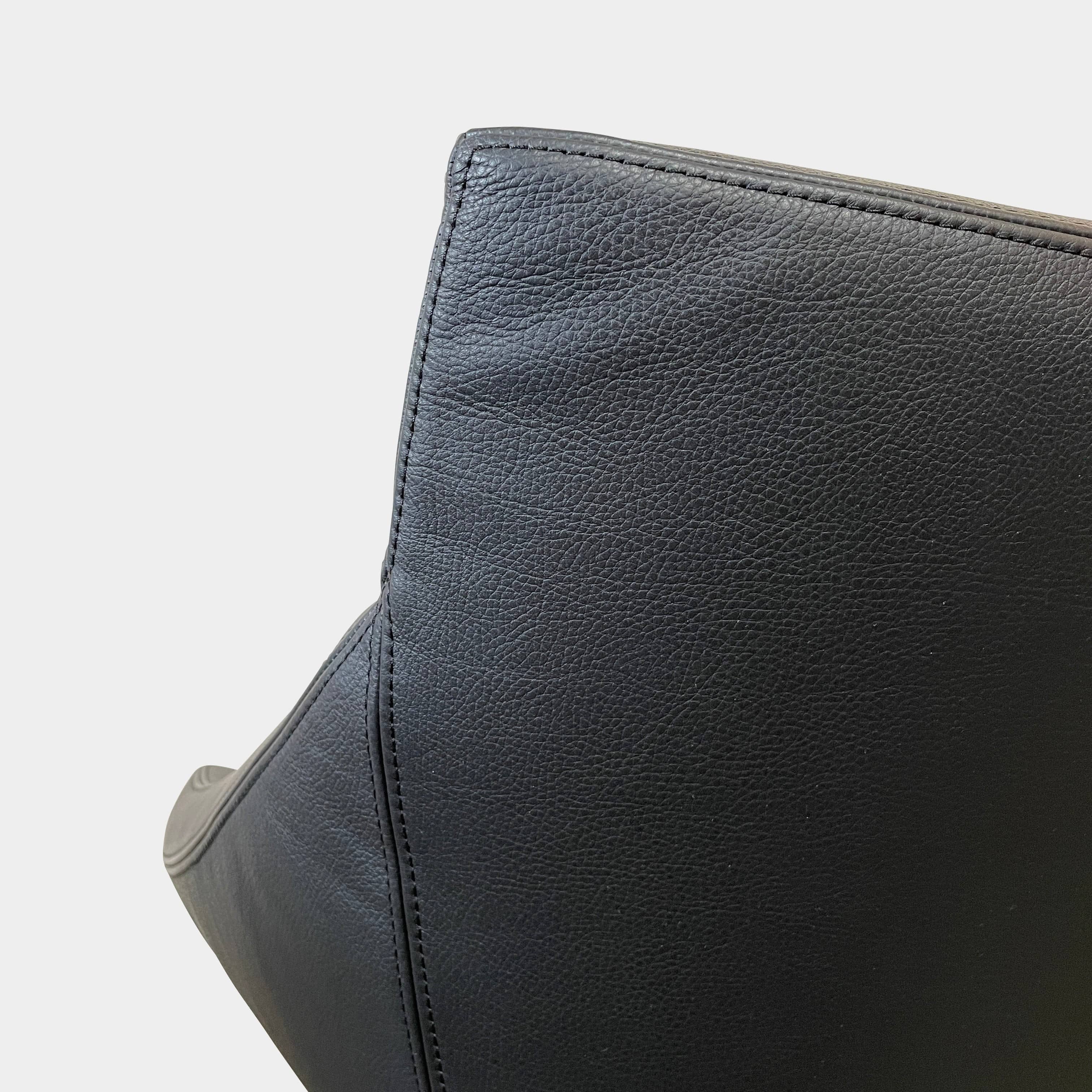 A compact black leather Team by Wellis Bocu Swivel Chair with a chrome base.