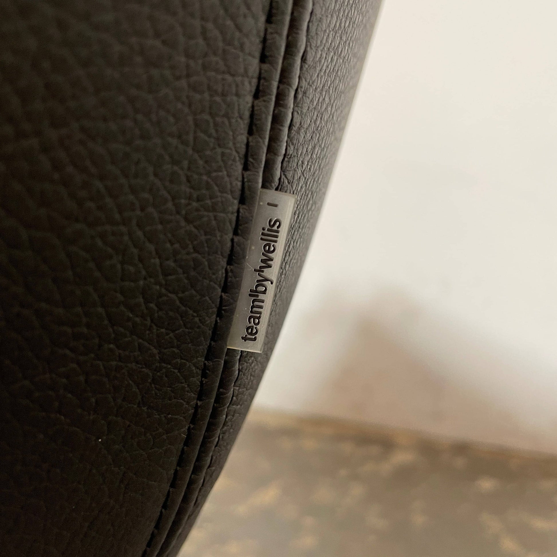 A compact black leather Team by Wellis Bocu Swivel Chair with a chrome base.