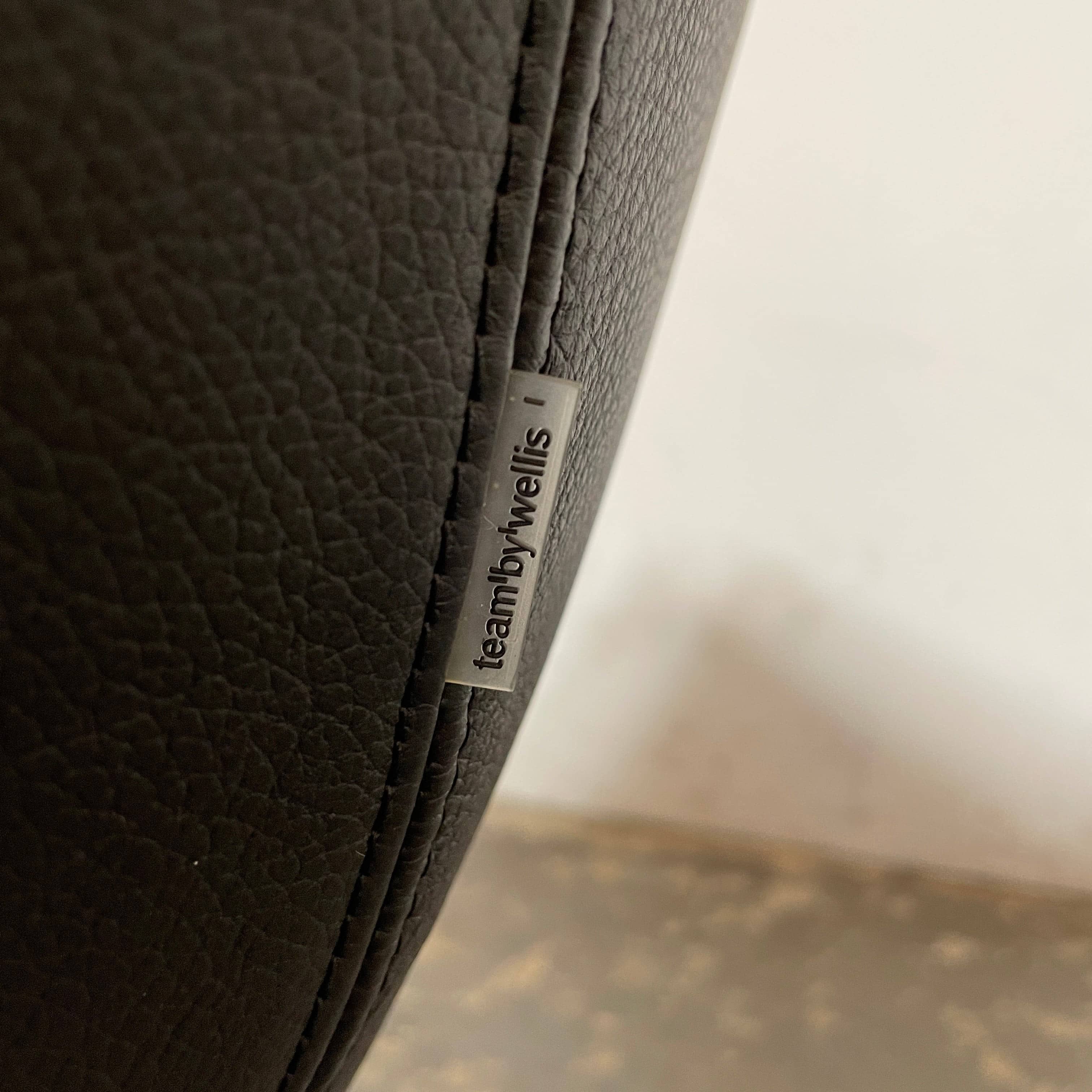 A compact black leather Team by Wellis Bocu Swivel Chair with a chrome base.