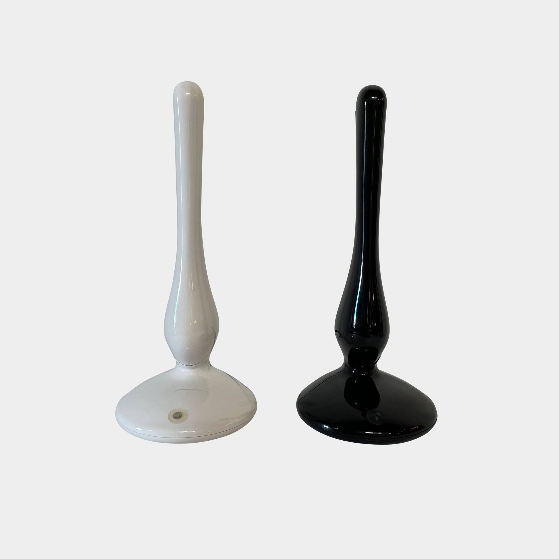 A modern white desk lamp with a curved design and a round base, reminiscent of Ross Lovegrove's aesthetic, akin to the elegance of Yamagiwa Geon Task Lights by Yamagiwa.