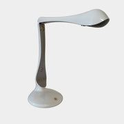 A modern white desk lamp with a curved design and a round base, reminiscent of Ross Lovegrove's aesthetic, akin to the elegance of Yamagiwa Geon Task Lights by Yamagiwa.