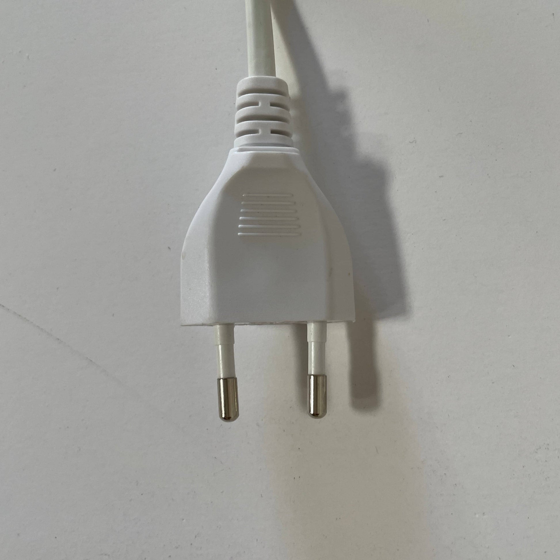 A modern white desk lamp with a curved design and a round base, reminiscent of Ross Lovegrove's aesthetic, akin to the elegance of Yamagiwa Geon Task Lights by Yamagiwa.