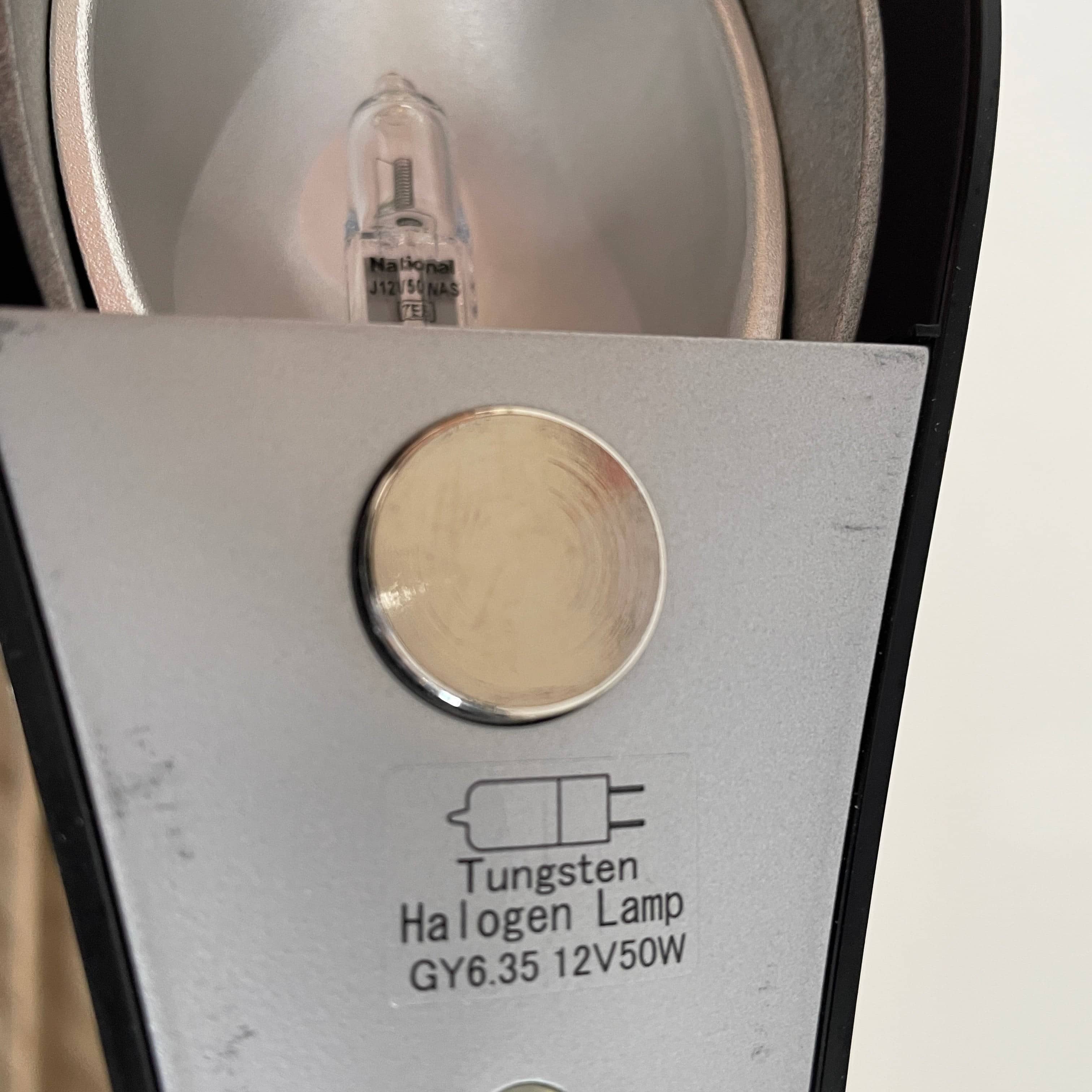 A modern white desk lamp with a curved design and a round base, reminiscent of Ross Lovegrove's aesthetic, akin to the elegance of Yamagiwa Geon Task Lights by Yamagiwa.