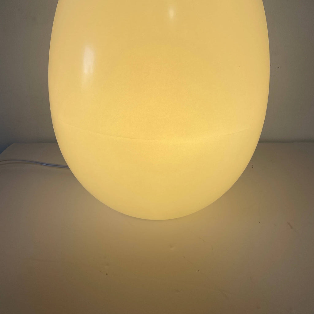 A soft yellow Yamagiwa L'uovo Table Lamp on a comforting white background.