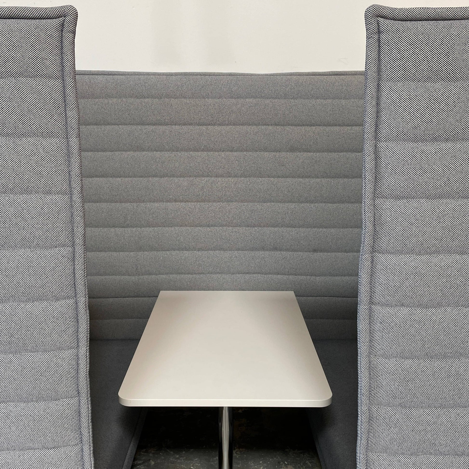 A set of comfortable and modular Vitra Alcove Cabin chairs with a table in the middle.