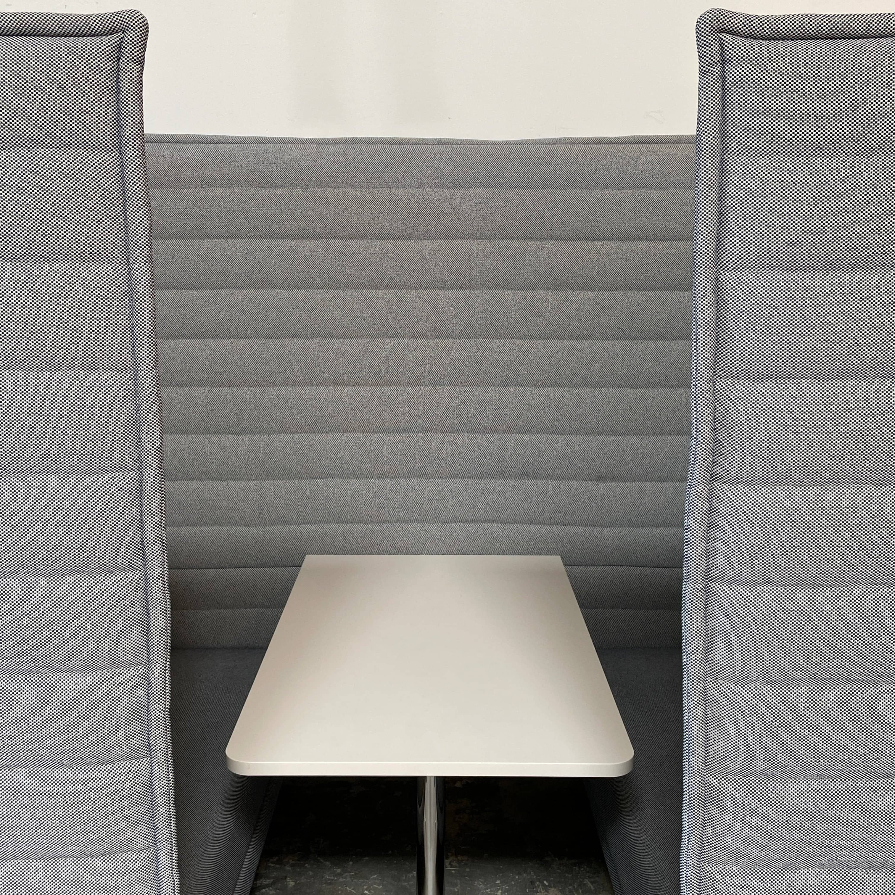 A set of comfortable and modular Vitra Alcove Cabin chairs with a table in the middle.
