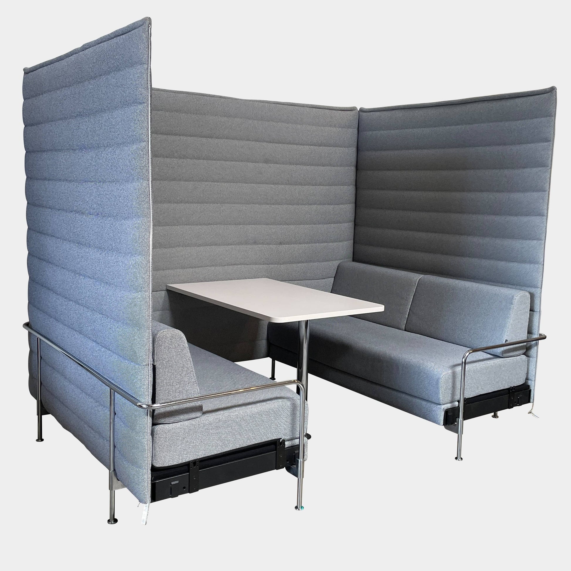 A set of comfortable and modular Vitra Alcove Cabin chairs with a table in the middle.