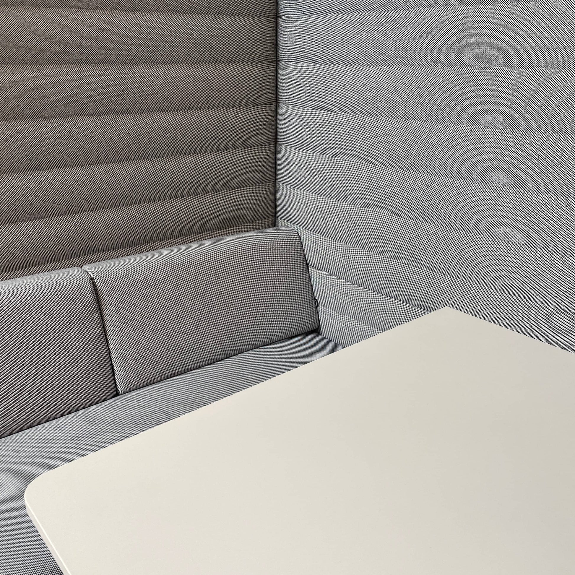 A set of comfortable and modular Vitra Alcove Cabin chairs with a table in the middle.