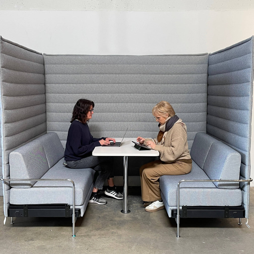 A set of comfortable and modular Vitra Alcove Cabin chairs with a table in the middle.