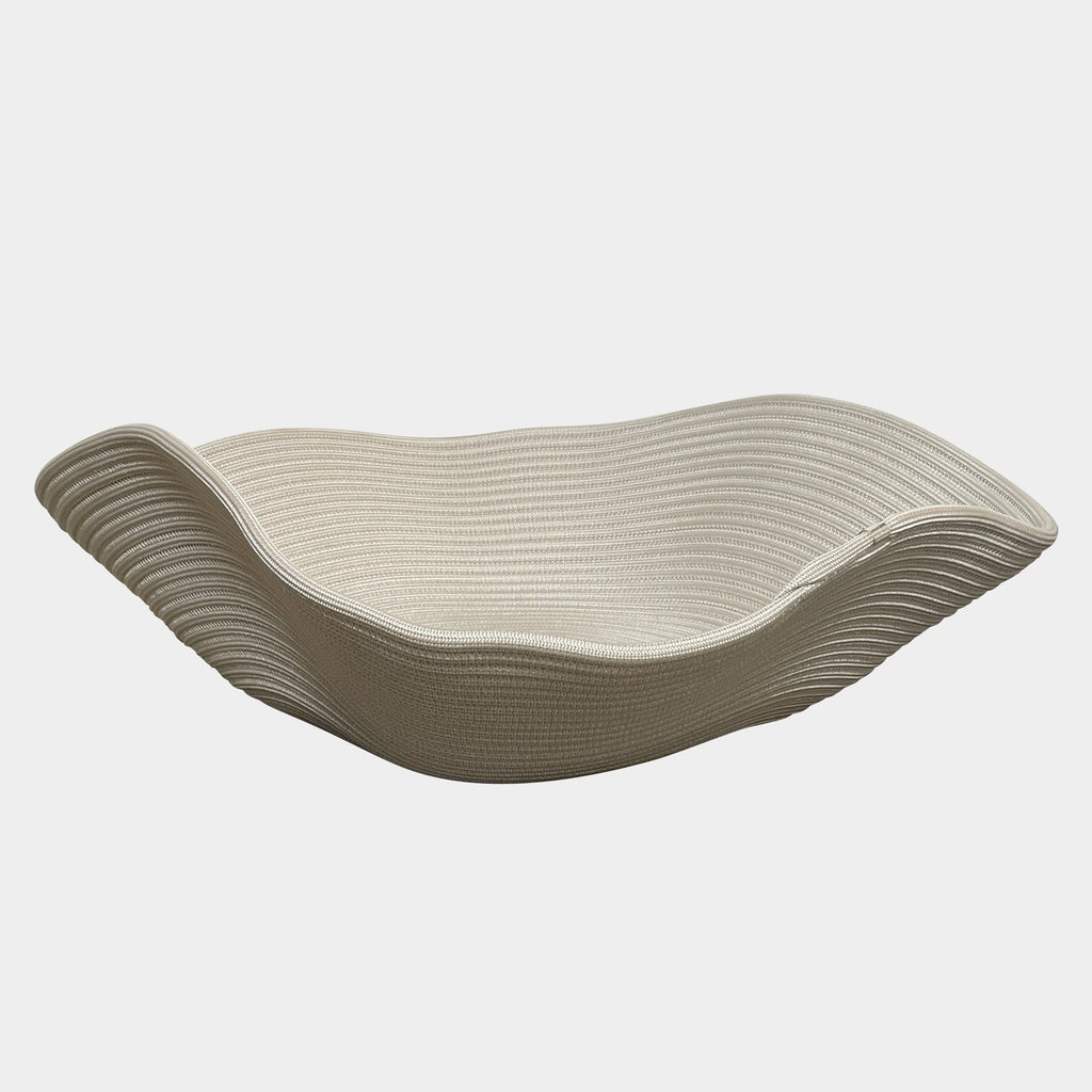 A Paola Lenti Sika Outdoor Basket with a wavy design, perfect for displaying towels or blankets.