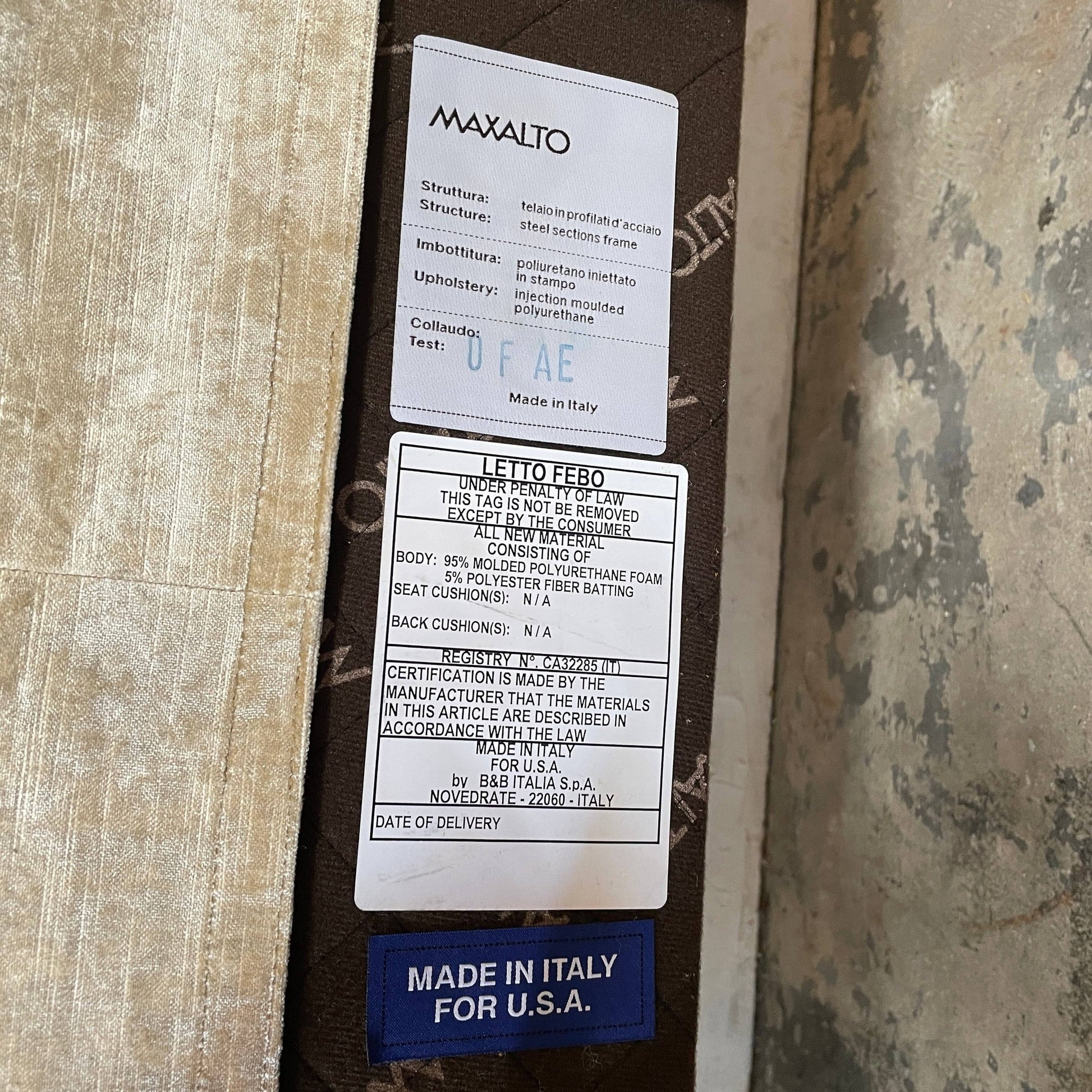 The Maxalto Febo Queen Bed is an upholstered bed frame featuring a headboard and two pillows, all elegantly wrapped in champagne-colored velvet. The frame boasts wooden slats for support, providing the refined touch of a luxury hotel bed. Shown without a mattress.