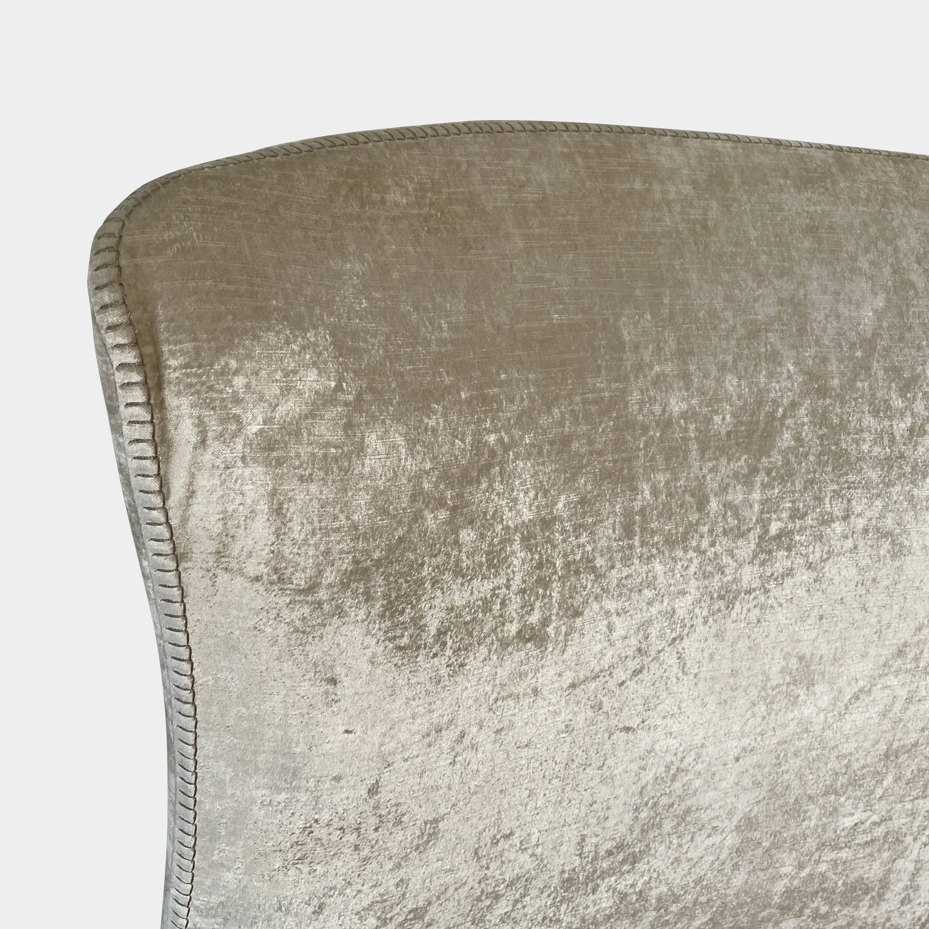 The Maxalto Febo Queen Bed is an upholstered bed frame featuring a headboard and two pillows, all elegantly wrapped in champagne-colored velvet. The frame boasts wooden slats for support, providing the refined touch of a luxury hotel bed. Shown without a mattress.