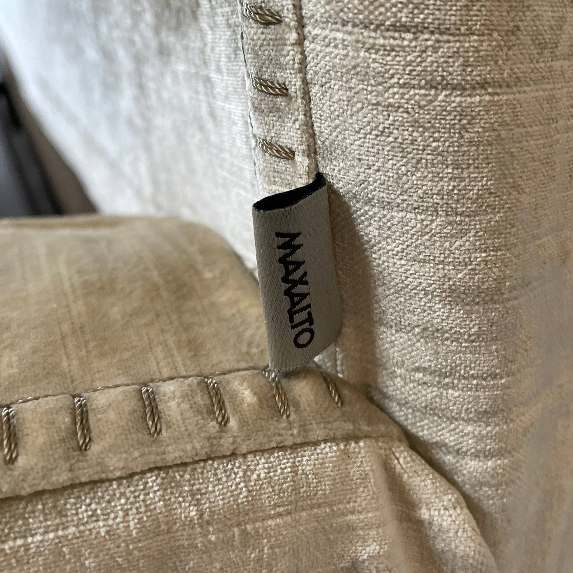 The Maxalto Febo Queen Bed is an upholstered bed frame featuring a headboard and two pillows, all elegantly wrapped in champagne-colored velvet. The frame boasts wooden slats for support, providing the refined touch of a luxury hotel bed. Shown without a mattress.