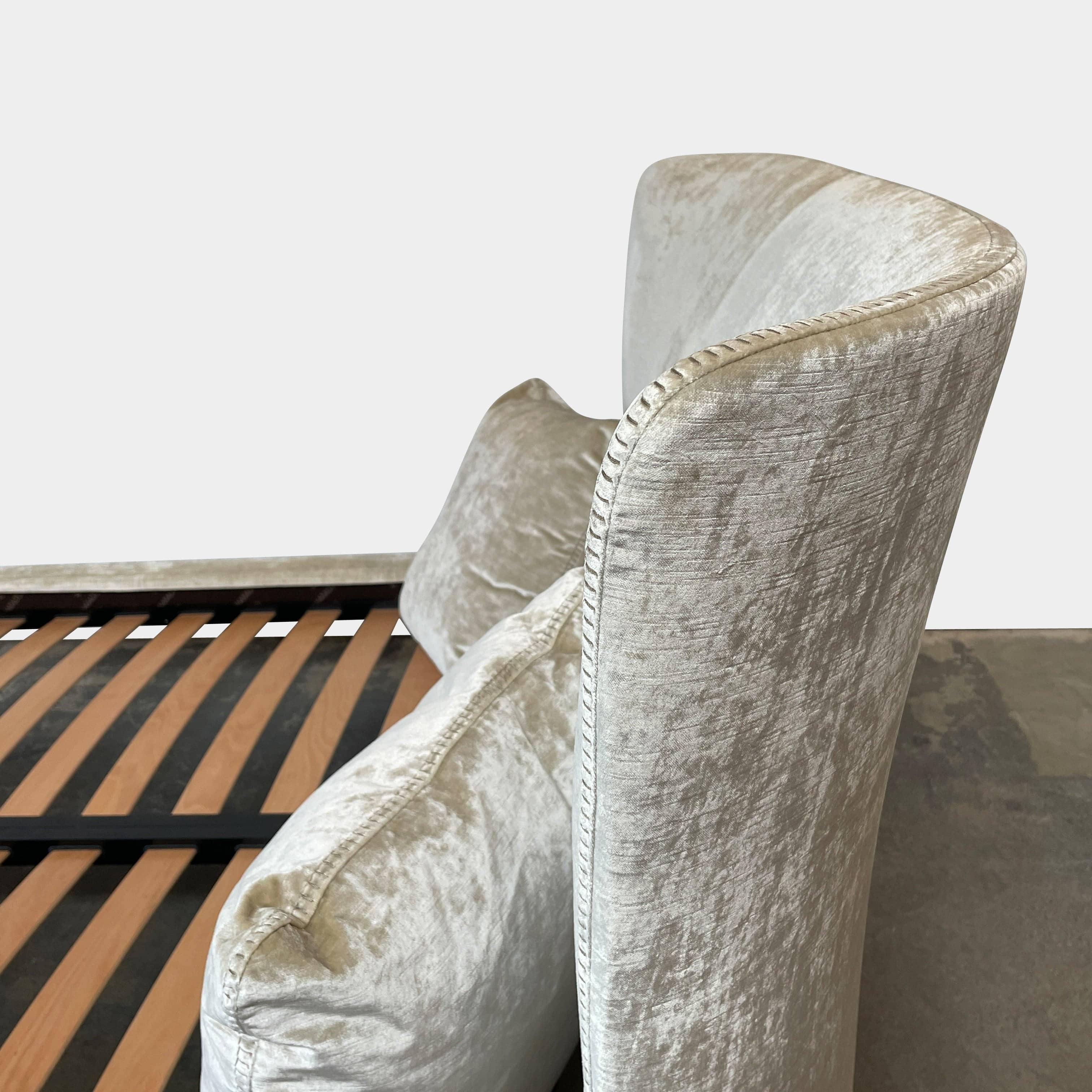 The Maxalto Febo Queen Bed is an upholstered bed frame featuring a headboard and two pillows, all elegantly wrapped in champagne-colored velvet. The frame boasts wooden slats for support, providing the refined touch of a luxury hotel bed. Shown without a mattress.