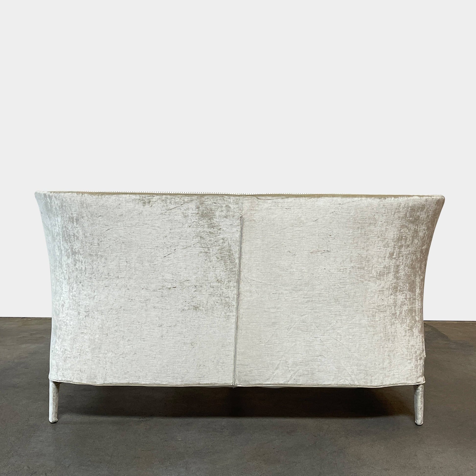 The Maxalto Febo Queen Bed is an upholstered bed frame featuring a headboard and two pillows, all elegantly wrapped in champagne-colored velvet. The frame boasts wooden slats for support, providing the refined touch of a luxury hotel bed. Shown without a mattress.