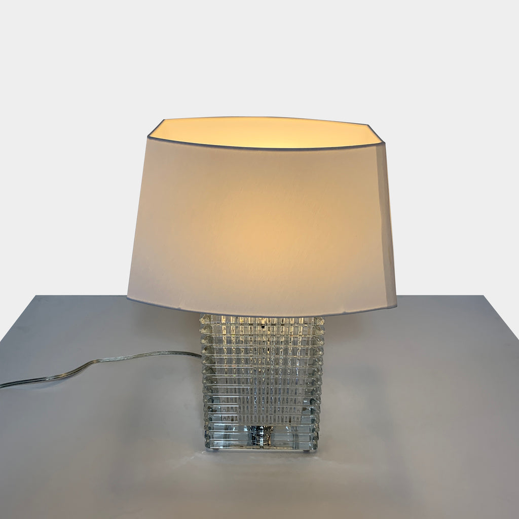 A Baccarat Eye Table Lamp with a white shade.